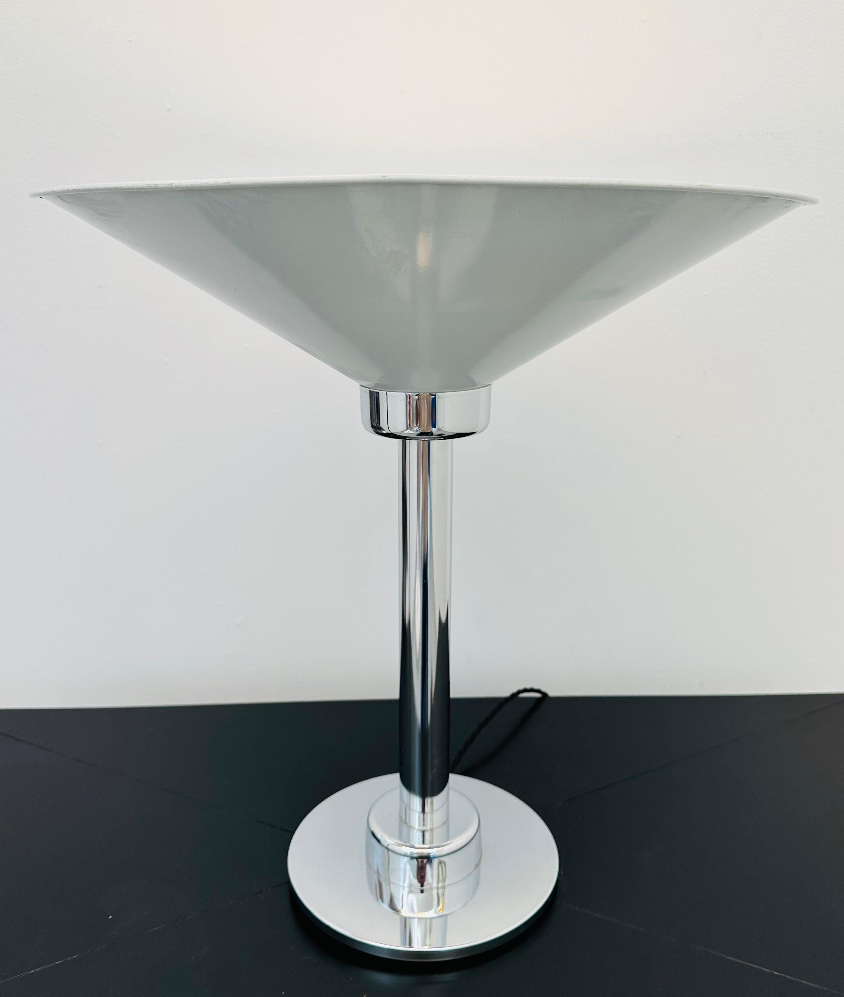 1970s Italian space age polished chrome and white enamelled metal conical uplighter table lamp.  Rewired by a professional electrician with a black silk flex.  In good vintage condition with some signs of wear around the edges of the cone.  The cone