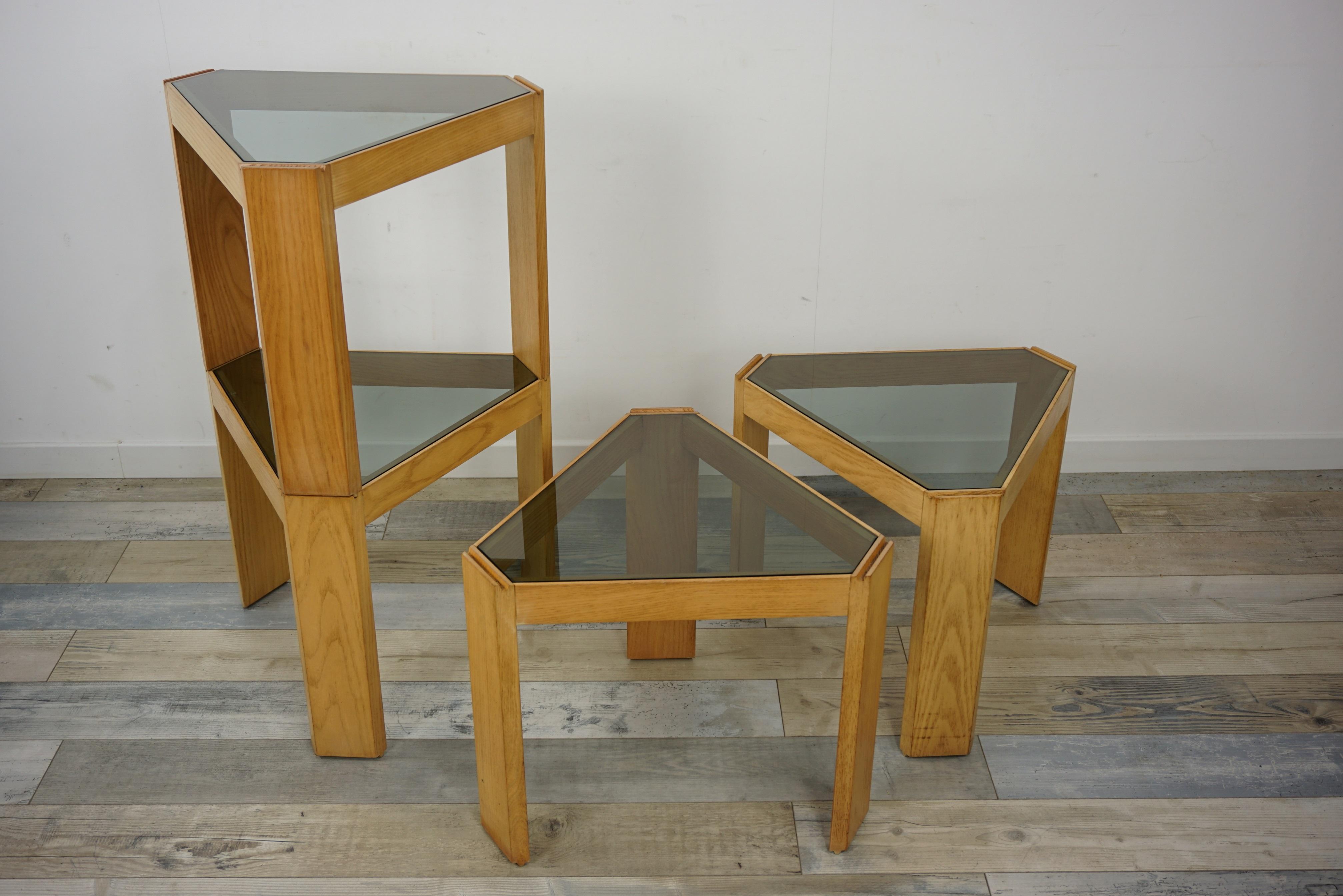 1970s Italian design set of 4 modular tables from Porada Arredi: Set of 4 triangular, stackable and modular tables, Tony model, composed of a triangular structure in ash decorated with a smoked triangular glass. Ingenious, each table has grooves to