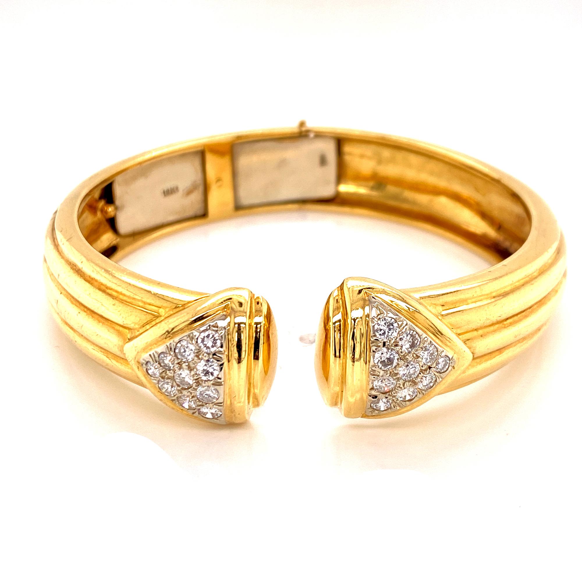 Beautiful diamond hinged cuff bracelet fashioned in 18 karat yellow gold. The ribbed cuff is circa 1970's, and features 20 round brilliant cut diamonds weighing 1.00 carat total weight. The diamonds are graded G-H color and VS clarity. 

The cuff