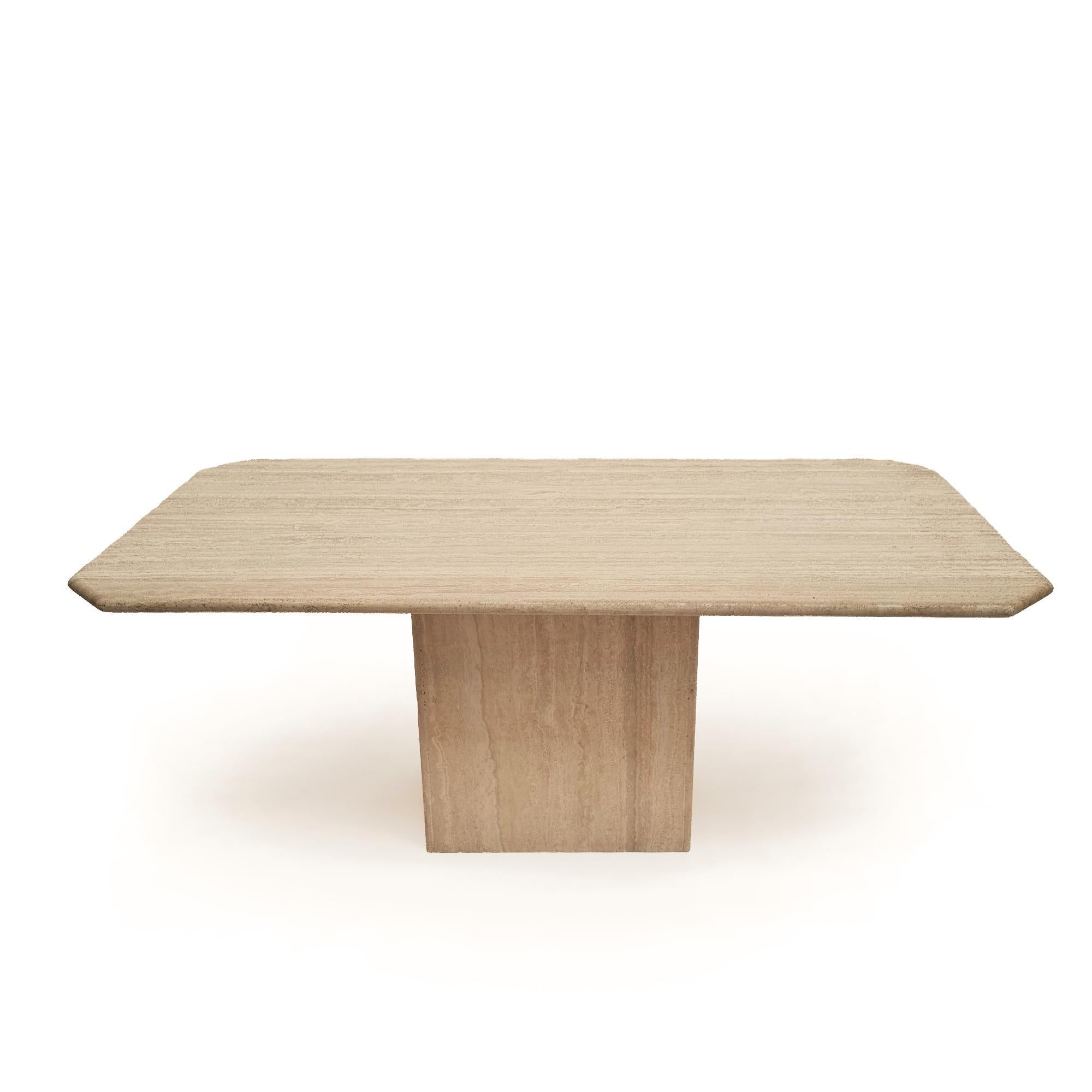 Presenting an exquisite Italian dining table from the 1970s, unbranded yet radiating timeless elegance. Its distinctive curvy edges rest upon a rectangular travertine column base, showcasing the beauty of natural stone.

This versatile piece