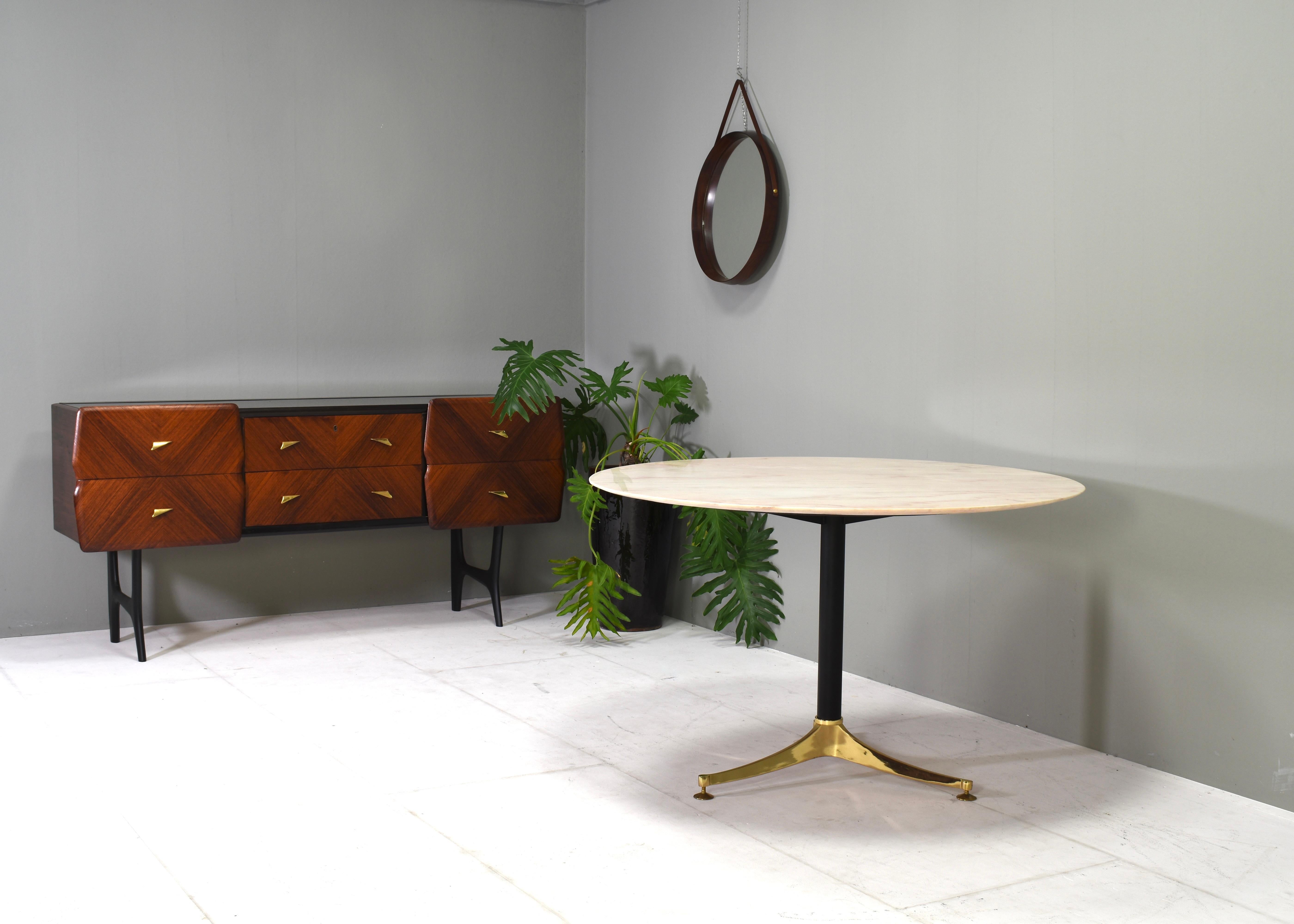 Gorgeous Italian dining table with Rosé / Pink marble top with elegant tapered edge. The base is made of a heavy tripod solid brass foot and black lacquered metal. It has adjustable feet which are slightly adjustable in height for