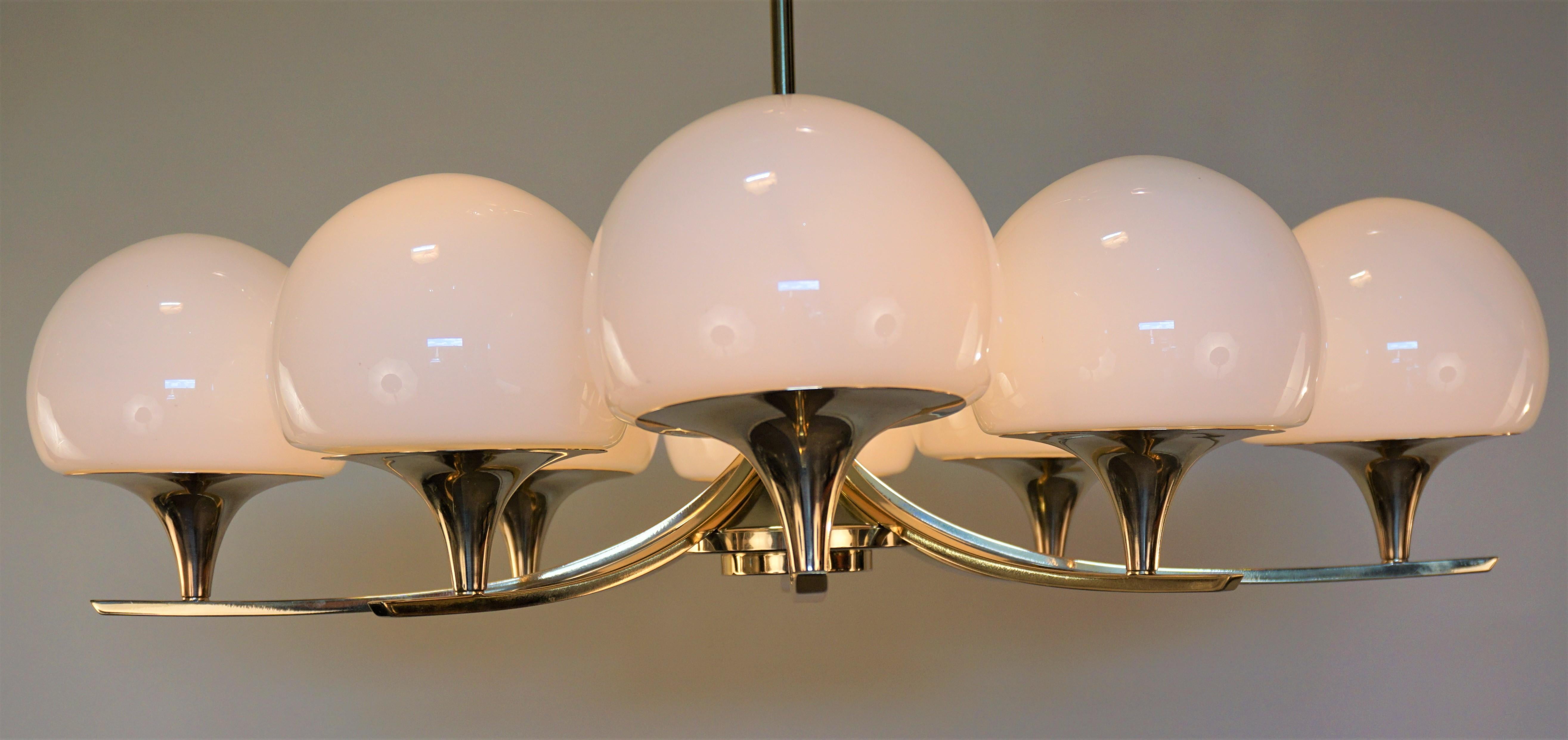 Simple but elegant eight-light polished bronze and opal glass chandelier.
