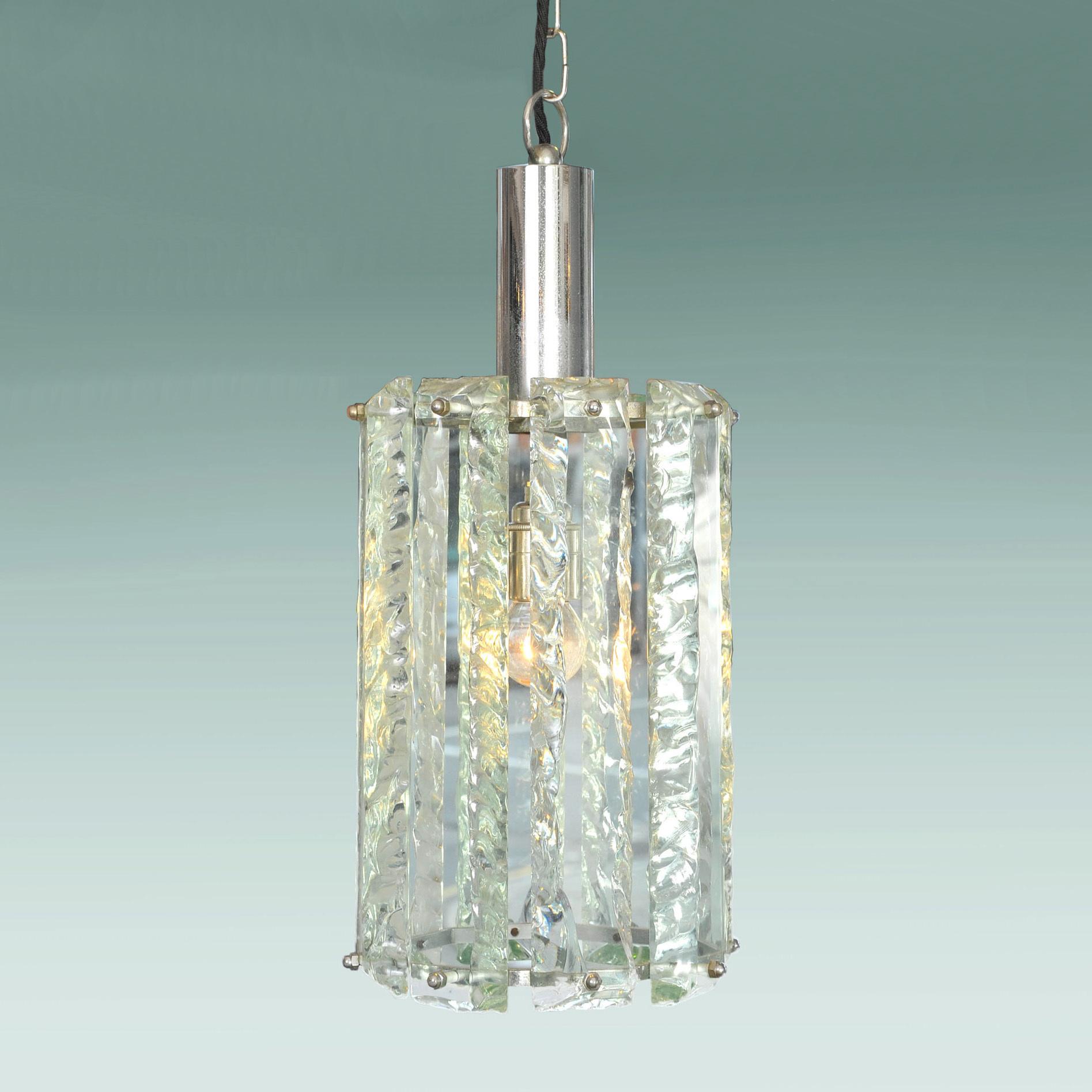 Pendentif en verre de Murano composé d'épaisses pièces de verre à effet de glace facettées en eau de nil pâle formant un abat-jour circulaire soutenu par sa monture et ses fixations chromées d'origine. Dans le style de Kalmar