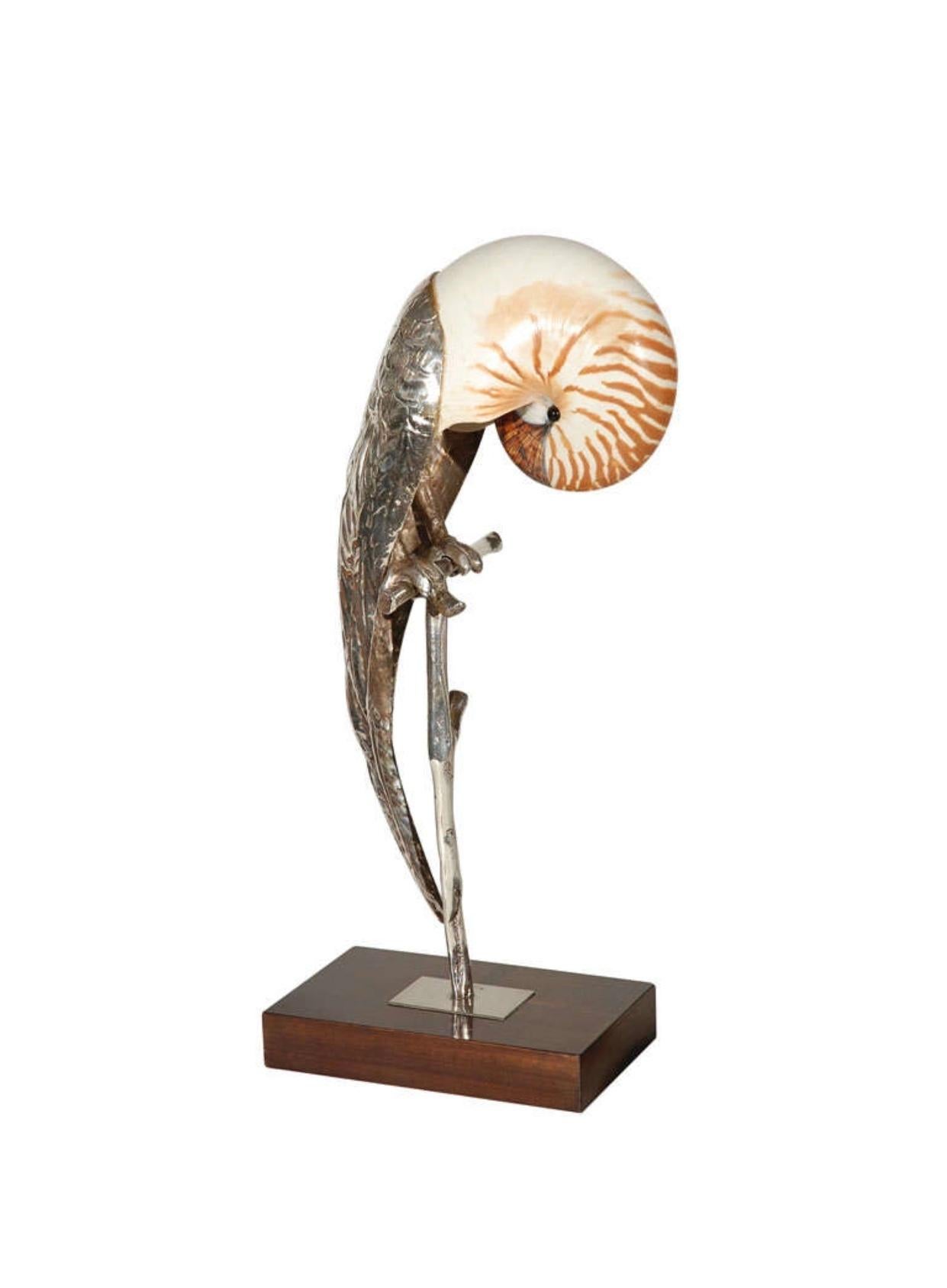 A beautiful hand crafted bird sculpture perched on a silver plated custom stand integrating a polished nautilus seashell by Gabriella Binazzi - signed. 



