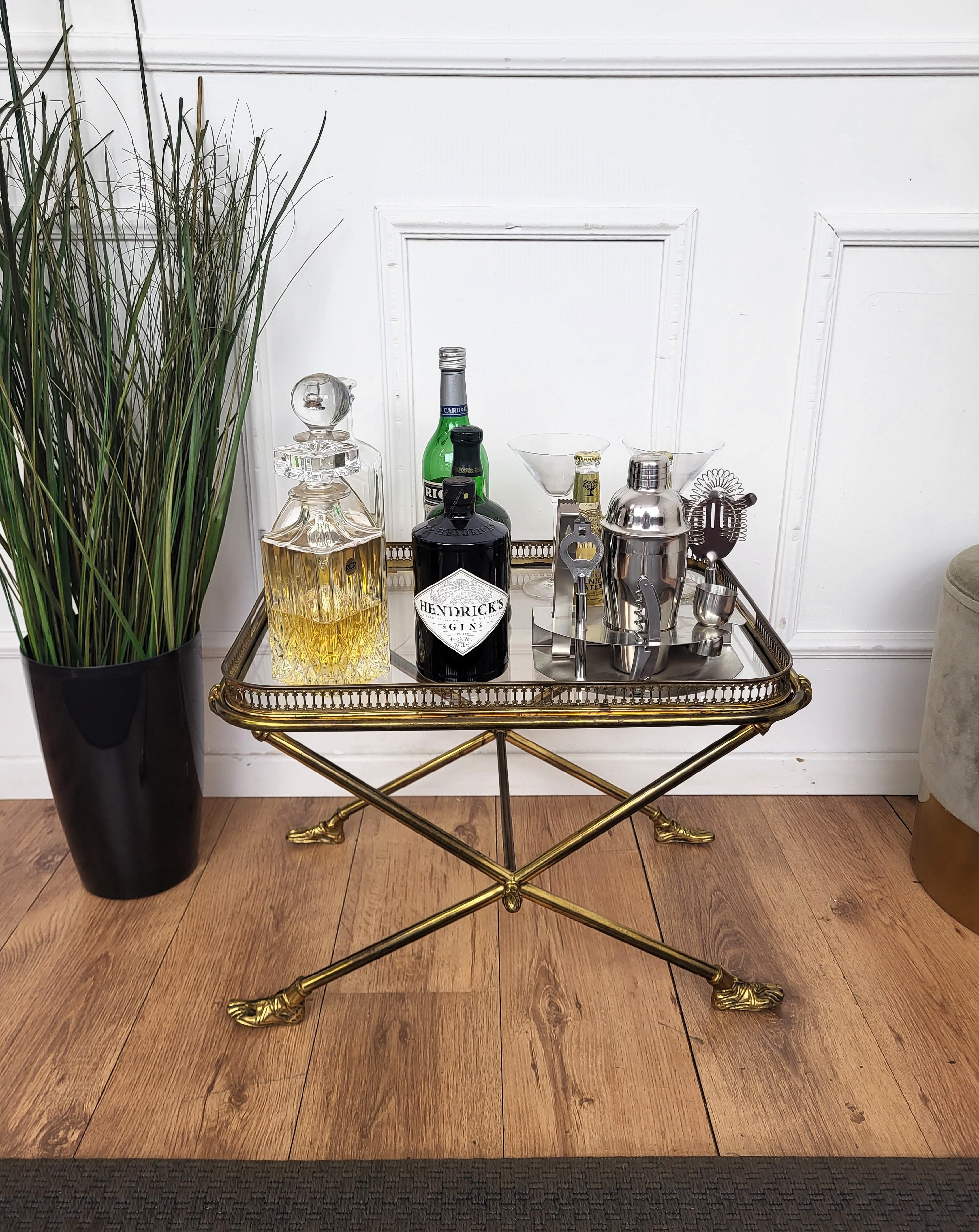 Magnifique et élégante table d'appoint en verre et laiton doré brillant, datant des années 60-70, avec plateau amovible. Cette pièce unique est mise en valeur par les mains et les pieds sculptés qui tiennent et soutiennent le plateau. Une pièce