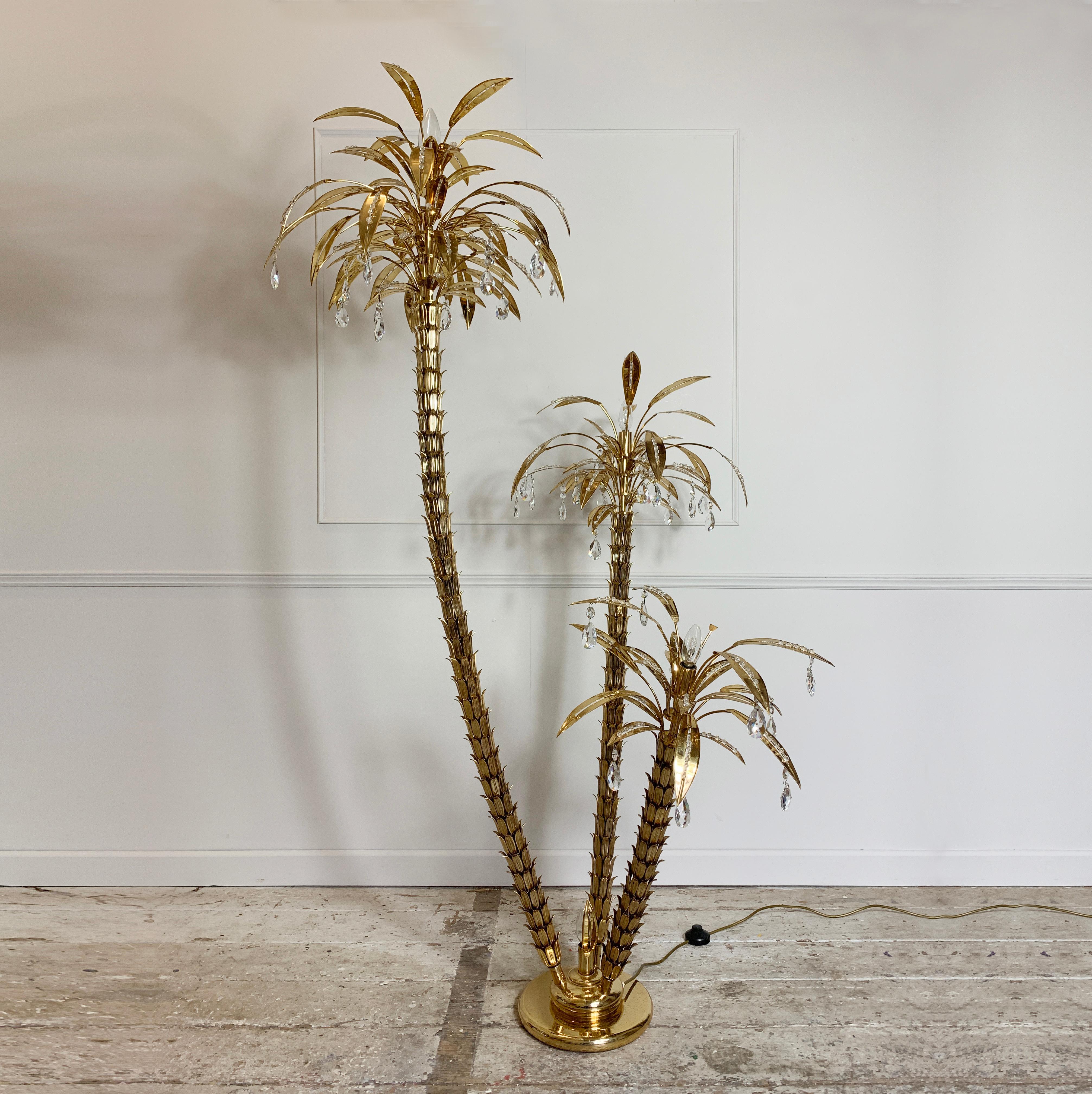 Large statement gilt and crystal palm tree floor lamp,
1970s, Italy
Three gilt brass palm trees are set into a weighted gilt base
The palm heads are full with brass leaves inset with glass crystals and hanging drops
Measures: 182cm height, 115cm