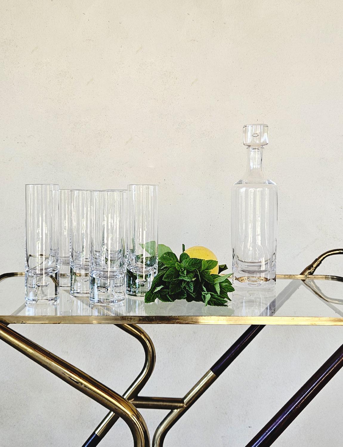 A set of six highball Italian aperitivo glasses each with large decorative air bubble in the base. The set comes with a matching heavy glass decanter with air bubble in the top. These types of glasses are typical of 1970s Italian bars serving