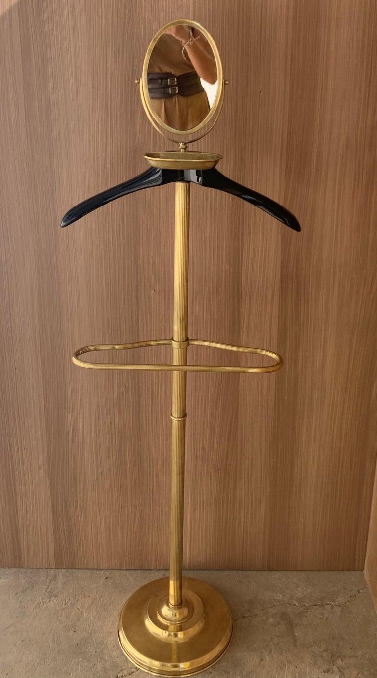 Vintage 1970s Italian brass and wood dressboy valet stand, with classic carved column and pedestals. It has a swivel mirror on the top. The hanger its height adjustable.
A great piece that perfectly adds to every home decor the typical glitz,