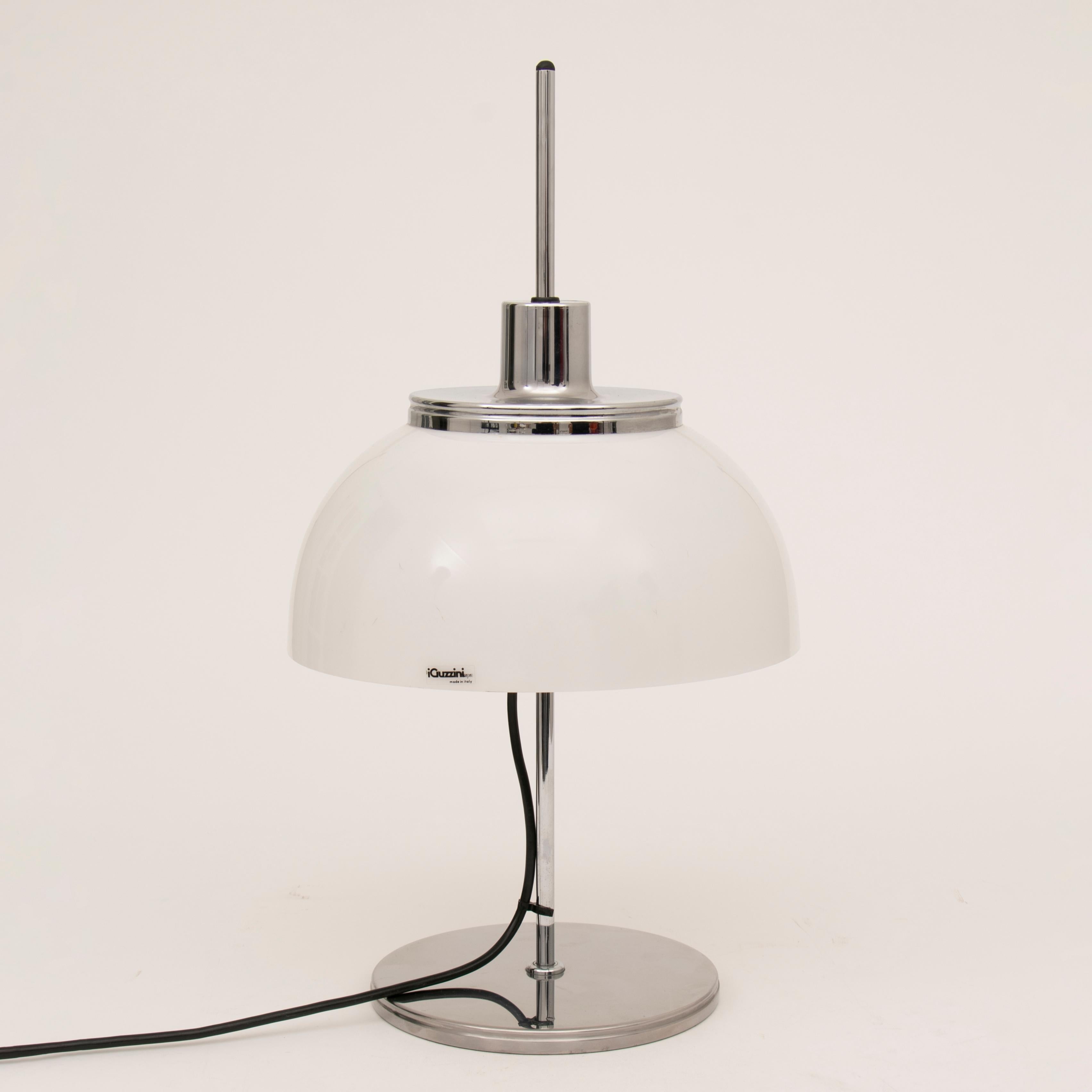 An Italian iGuzzini mushroom table lamp designed by Harvey Guzzini in the 1970s. The white, opaque, acrylic shade is adjustable in height, up and down, the central chrome column. The original Guzzini sticker is still present on the side of the