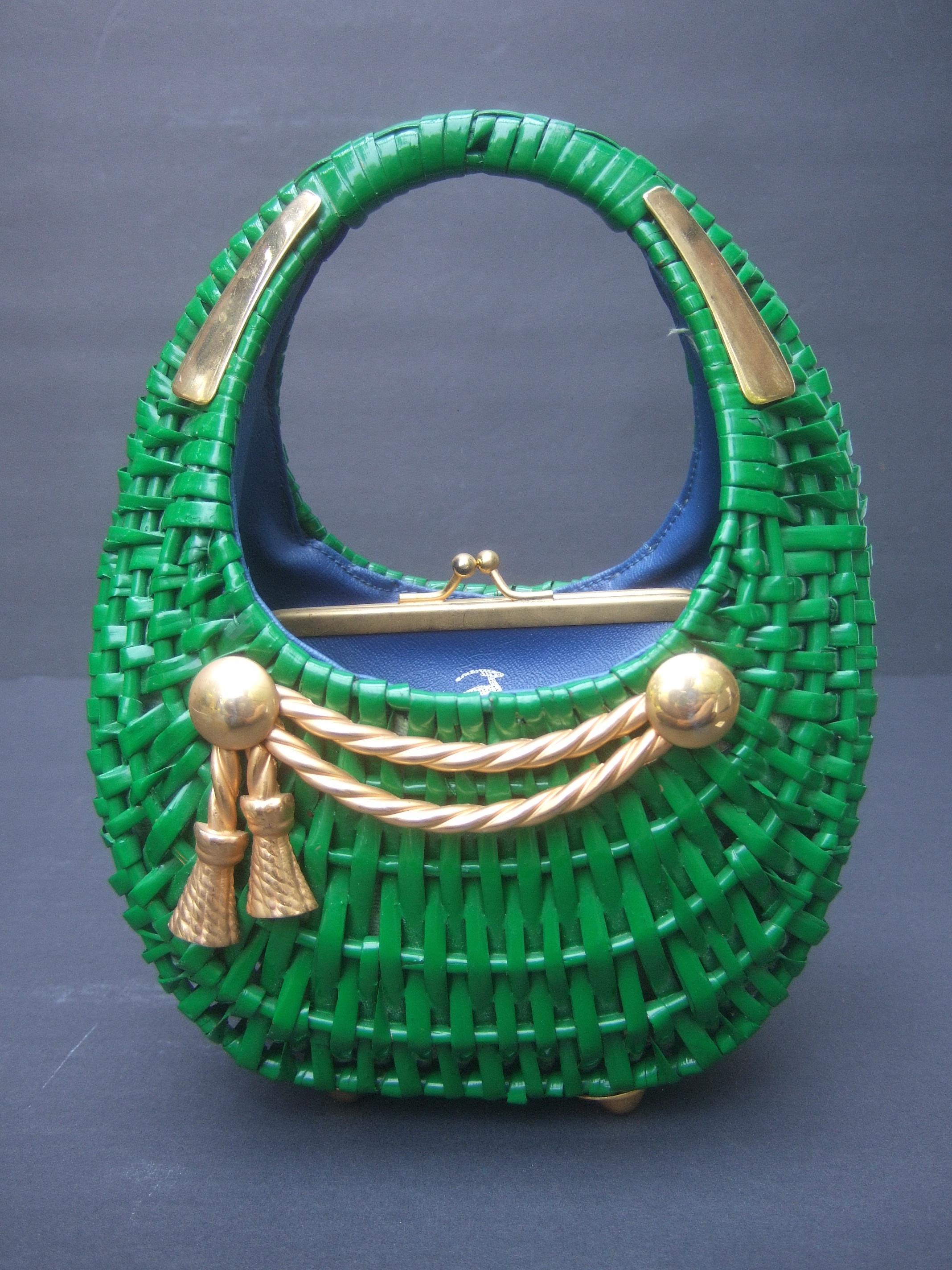 1970s Italian kelly green wicker diminutive size basket-shaped handbag designed by Koret 
The charming compact size wicker handbag is adorned with gilt metal decoration on the front exterior
A braided gold metal rope emblem is mounted on the front.