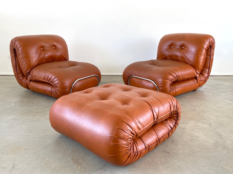 Pair of Italian leather lounge chairs in the style of the Soriana series by Afra & Tobia Scarpa for Cassina, Italy, 
1970's Bulbous design with chrome plated detail and wonderful curves. 
Matching ottoman included. 

Ottoman - 31.50