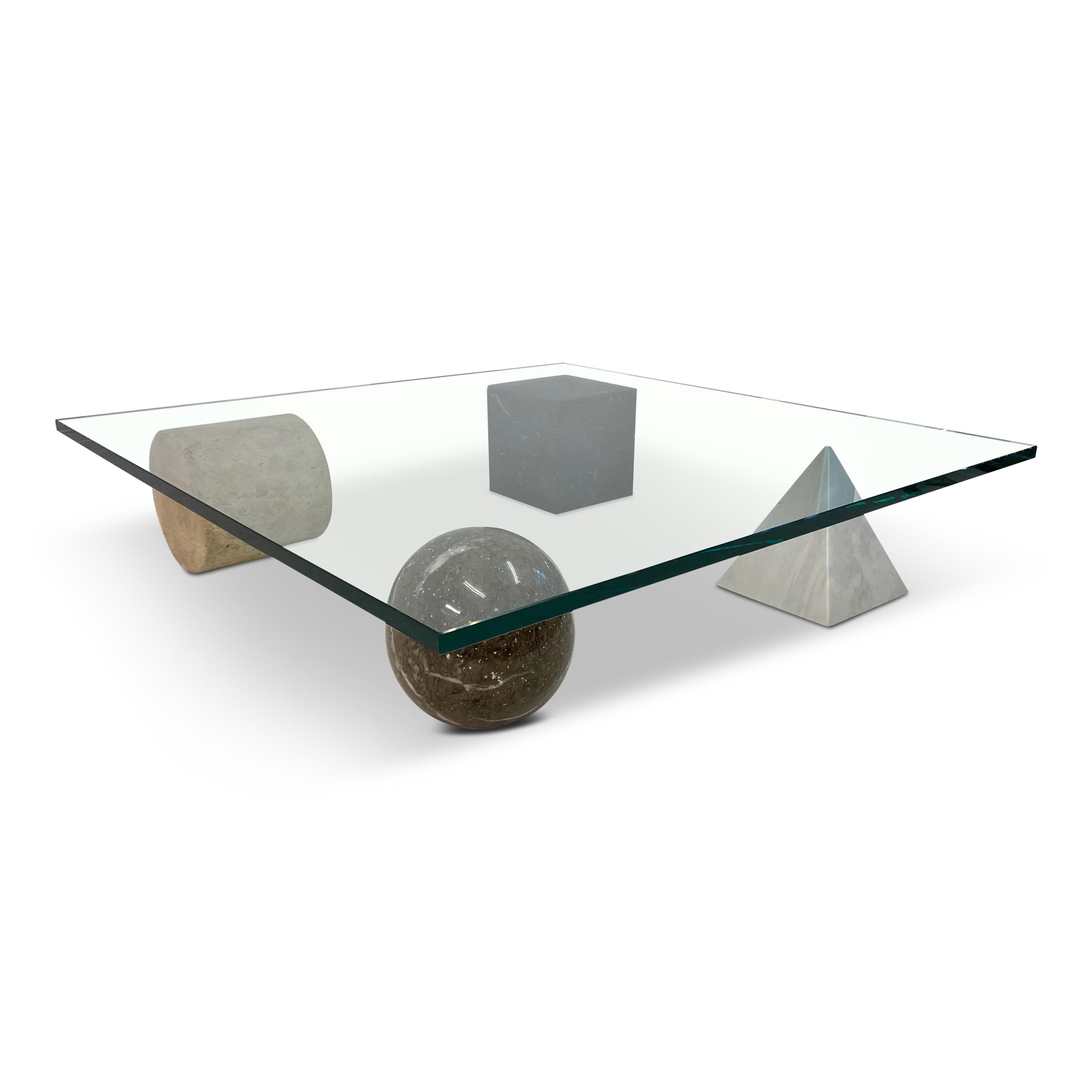 Metafora coffee table 

By Lella and Massimo Vignelli

Marble and travertine 3D shapes

Cube, pyramid, sphere and cylinder

Italy, 1979.

Measures: 20mm glass.