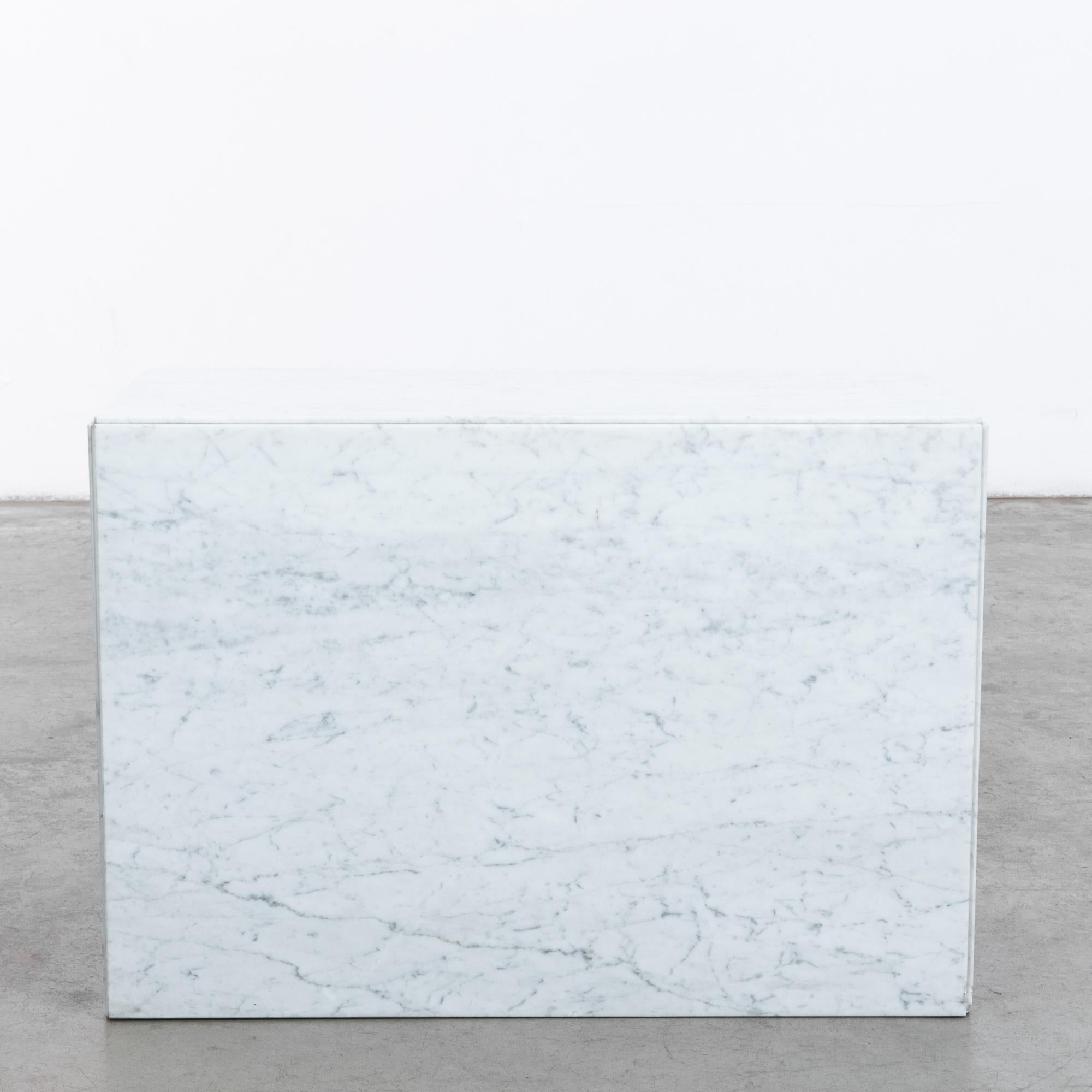 A marble coffee table from 1970s Italy. The solid block of the silhouette is articulated by the clean edges of the marble slabs. The cool color and nebulous veining of the polished surface gives a stylish inflection; the rich architectural history
