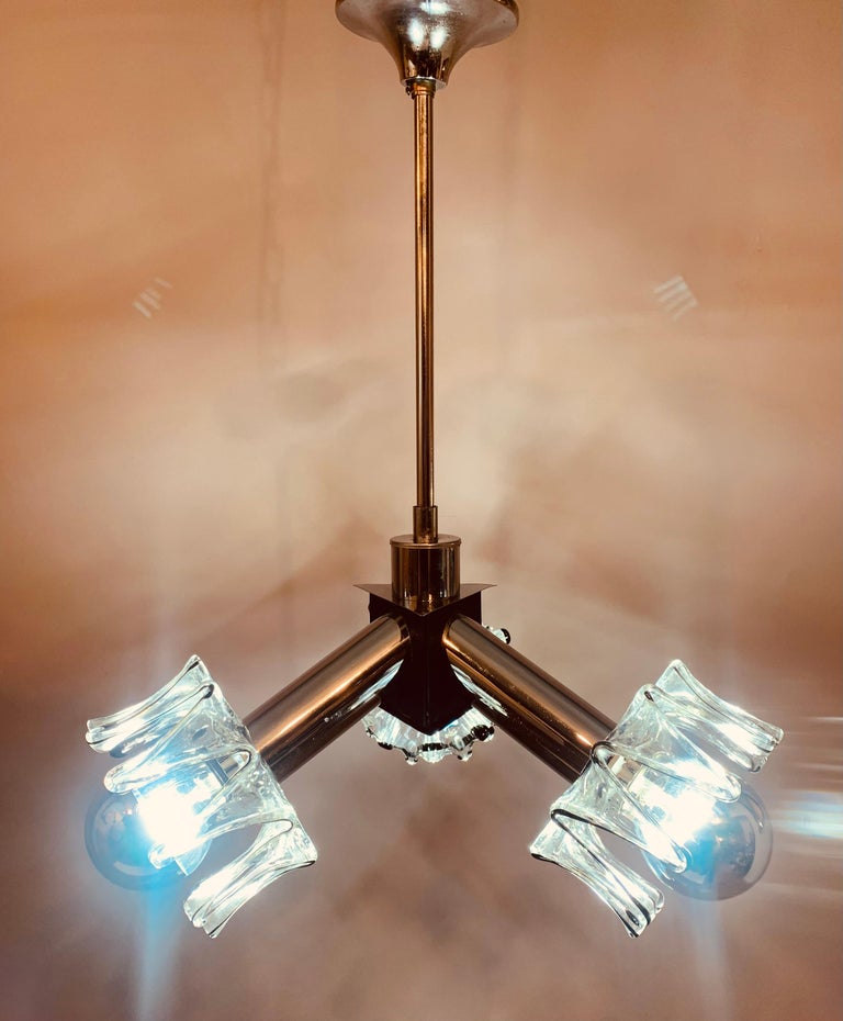 An unusual 1970s three-pronged ceiling light manufactured by Mazzega in Italy. Three chrome tubes hold a space-age spiked clear glass shade at each end with a thin black line running along their outer edges. The tubes are supported by a chrome tube