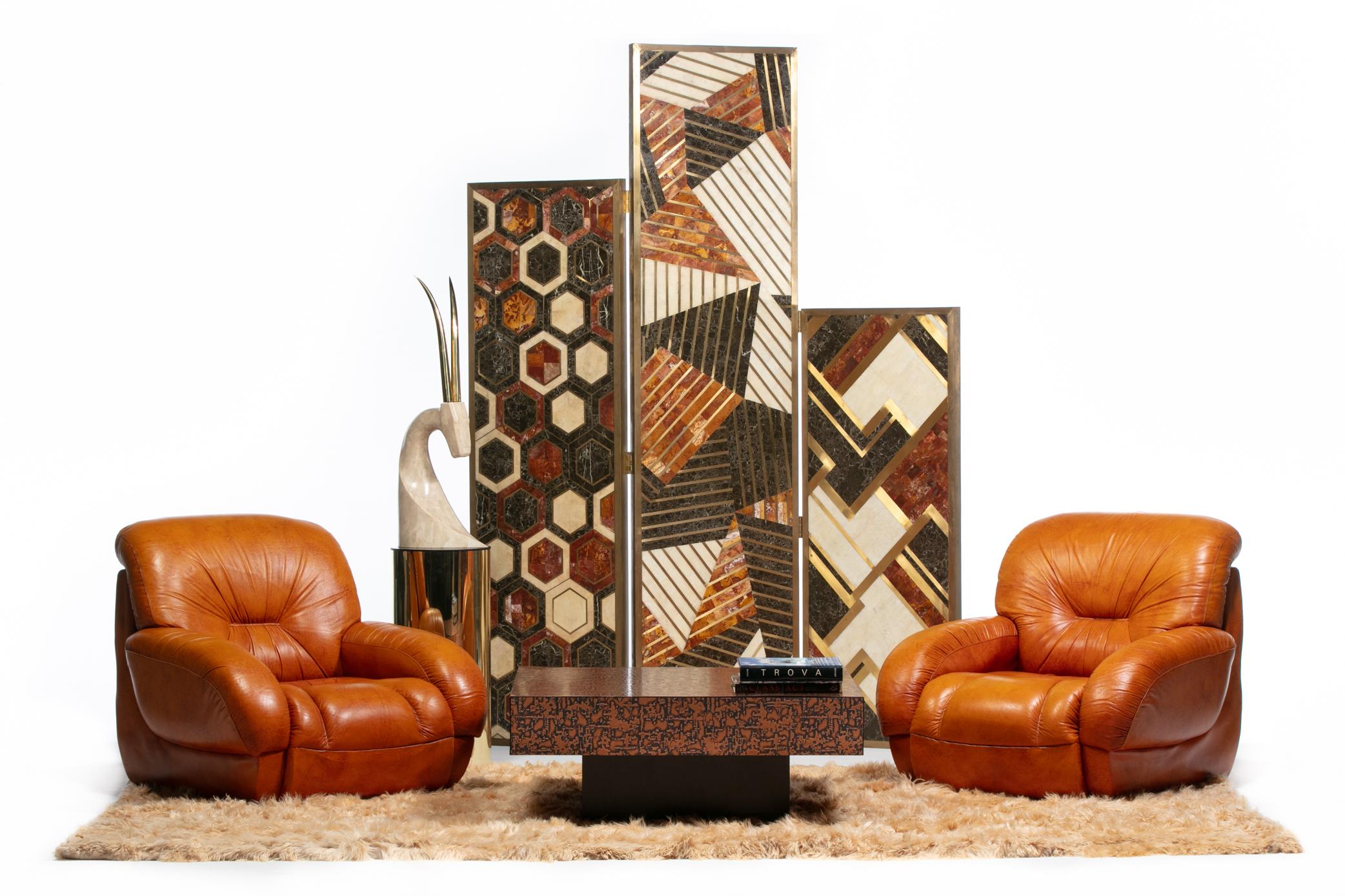 This pair of mid century modern Italian leather club chairs hits all the marks with a high design modern silhouette, warm and inviting original carmel color leather upholstery that pairs with all color schemes, and an all encompassing comfortable