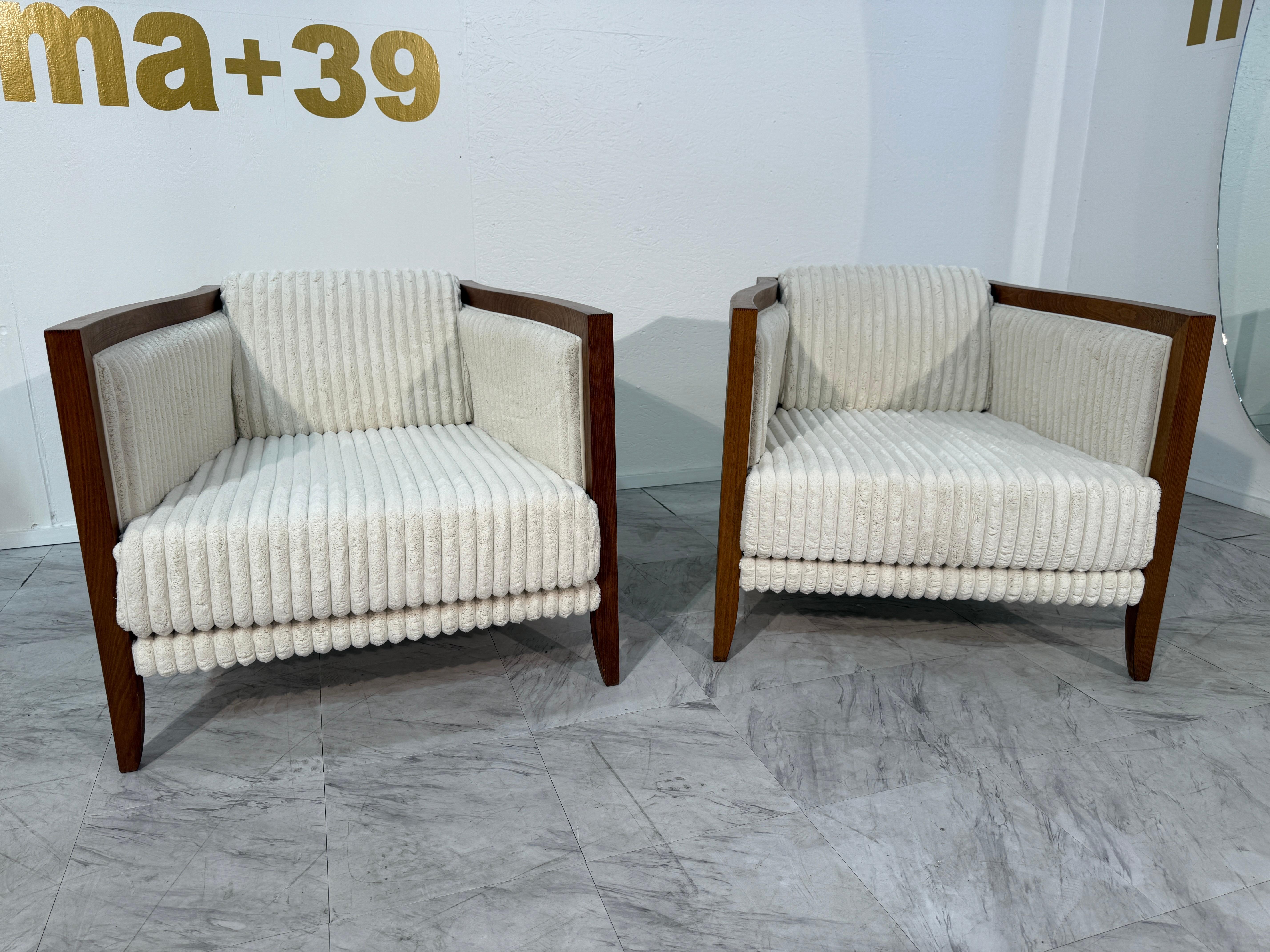 These 1970s lounge chairs blend sculptural form with plush comfort, embodying the refined aesthetics of the era. The angular wooden frames feature clean lines and subtly flared legs, lending them a striking architectural presence. Recently