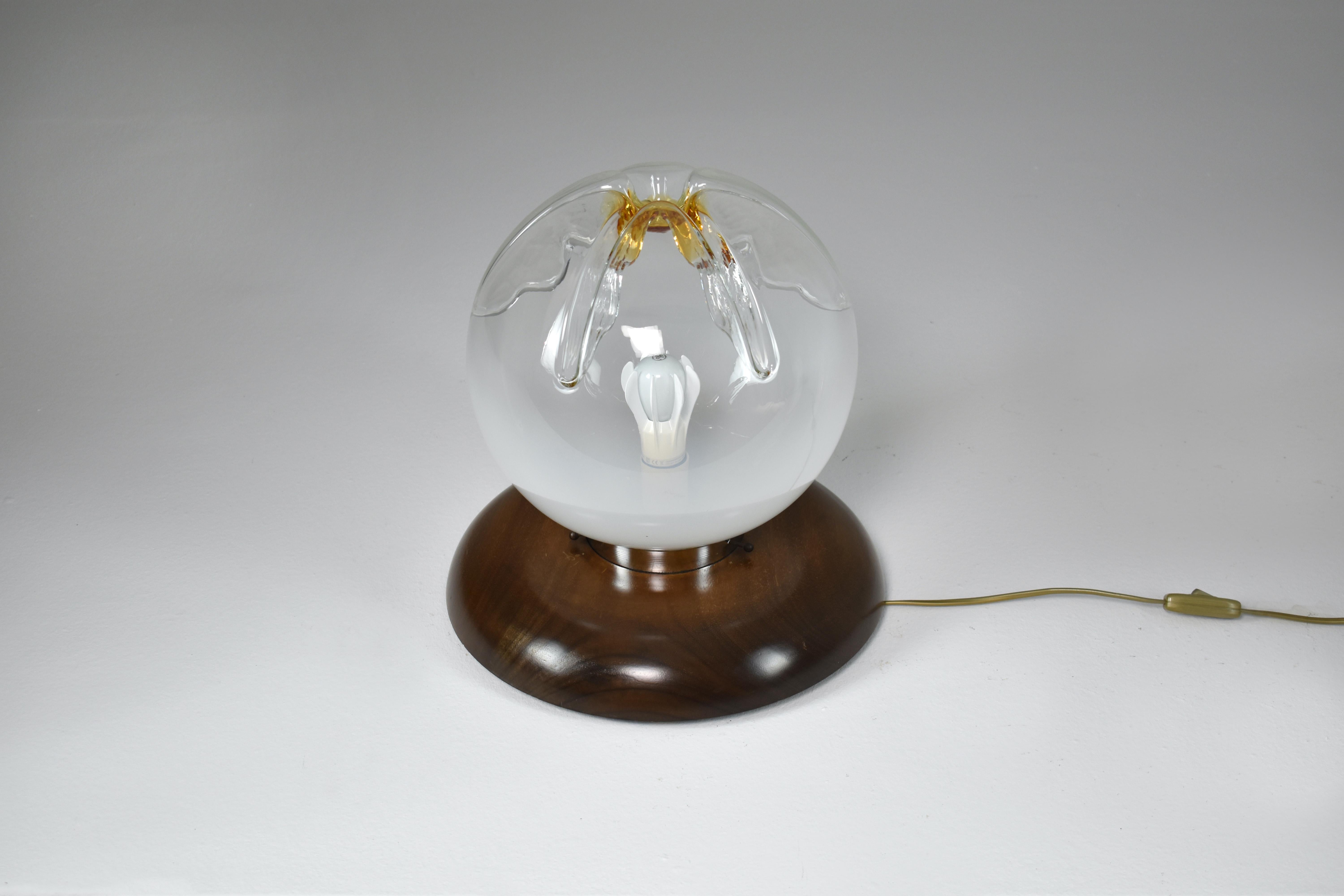 A very original Italian 20th-century vintage table accent lamp design. Its handblown glass-shaped globe, adorned with sculptural details and yellow tones, serves as a testament to the mastery of Italian mid-century craftsmanship.
The large shade is