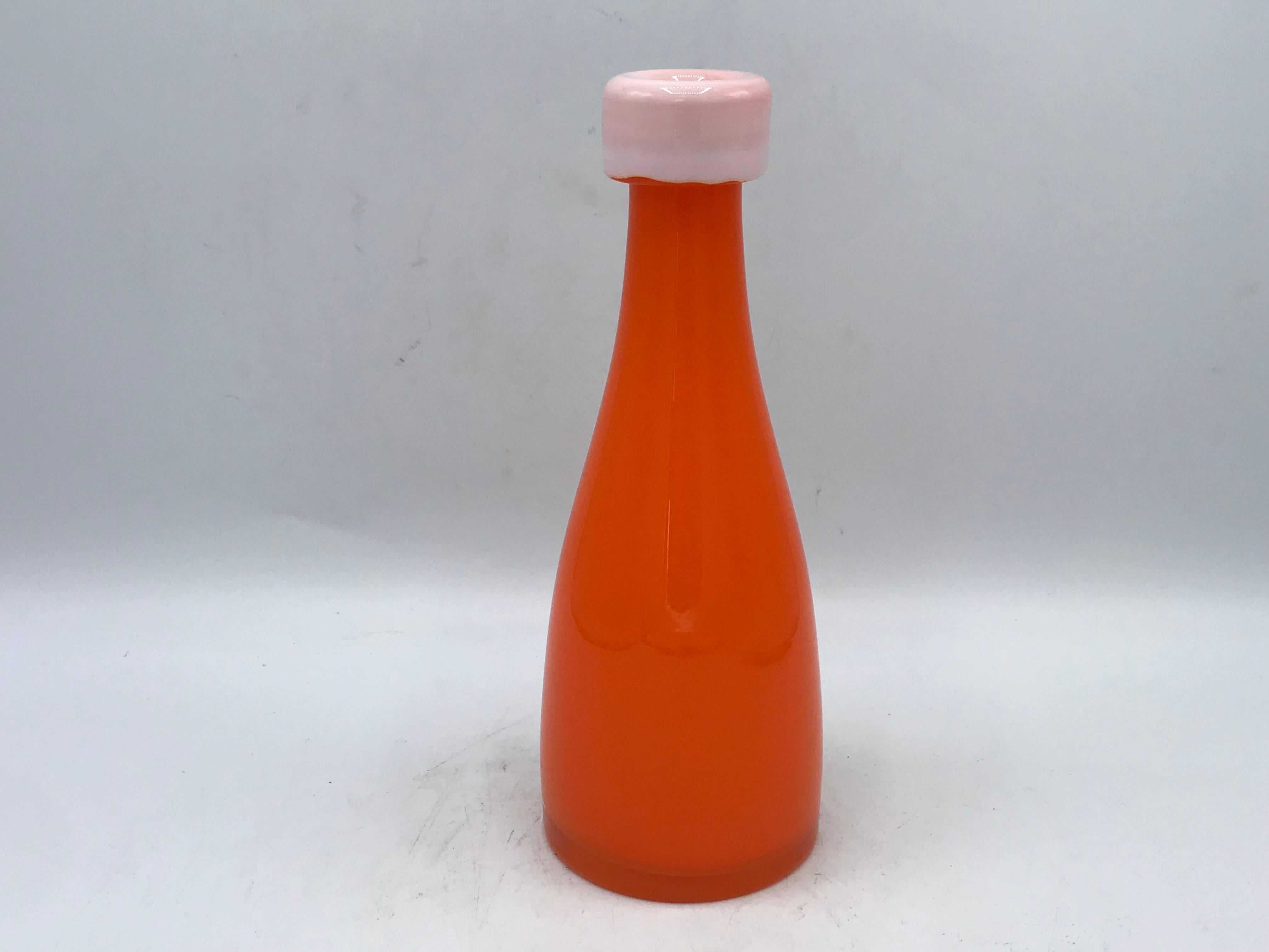 Listed is a fabulous and rare, 1970s Italian Murano glass orange bottle vase. This classic shape has a modern twist and pop of color with the sunburst orange, lightened with the white opening.