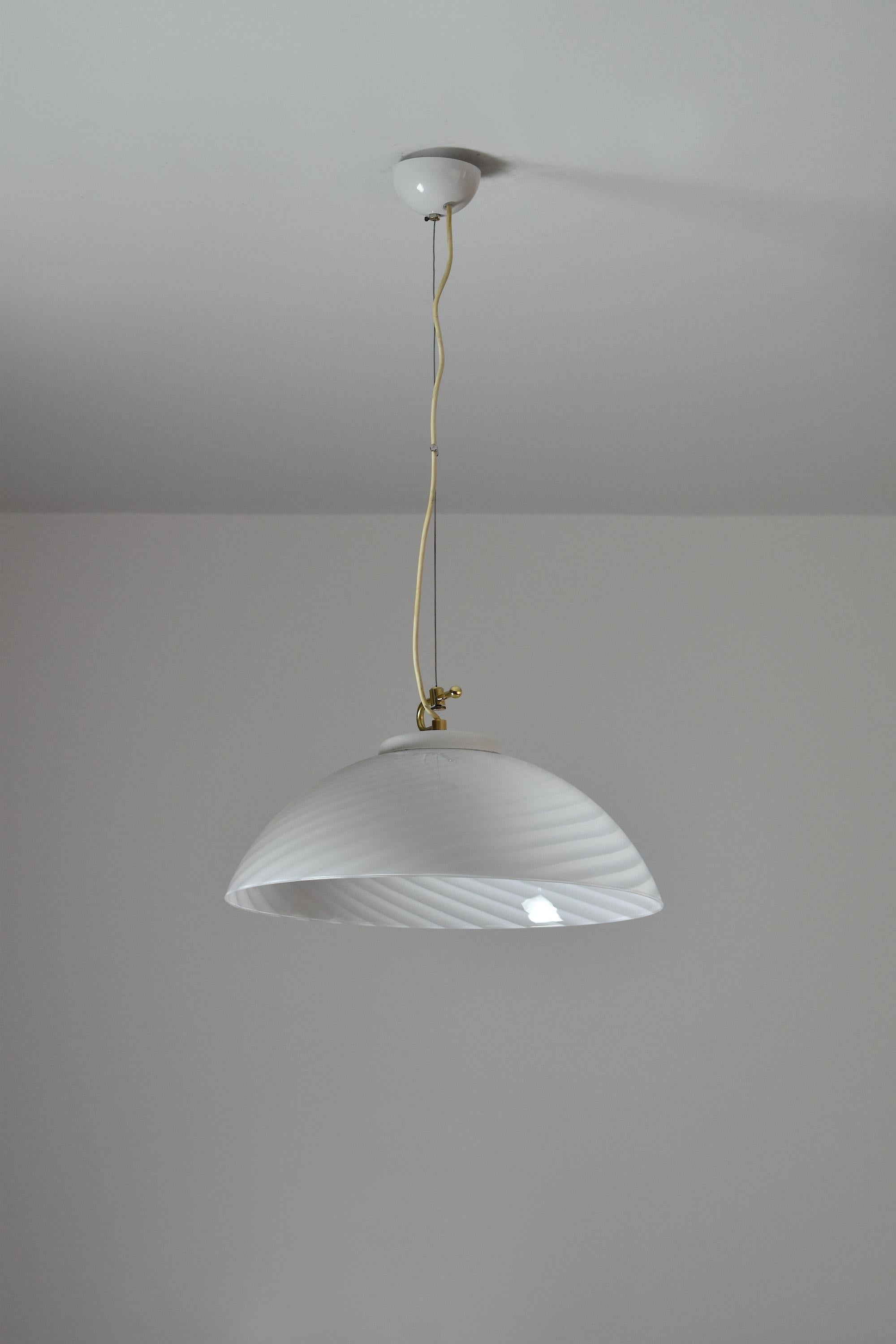 A beautiful 20th-century vintage pendant with a double adjustable wiring mechanism. The electrical wiring looks loose on the picture but it can be adjusted to be straight. 
The semi-spherical Murano glass shade is designed with opaline diagonal