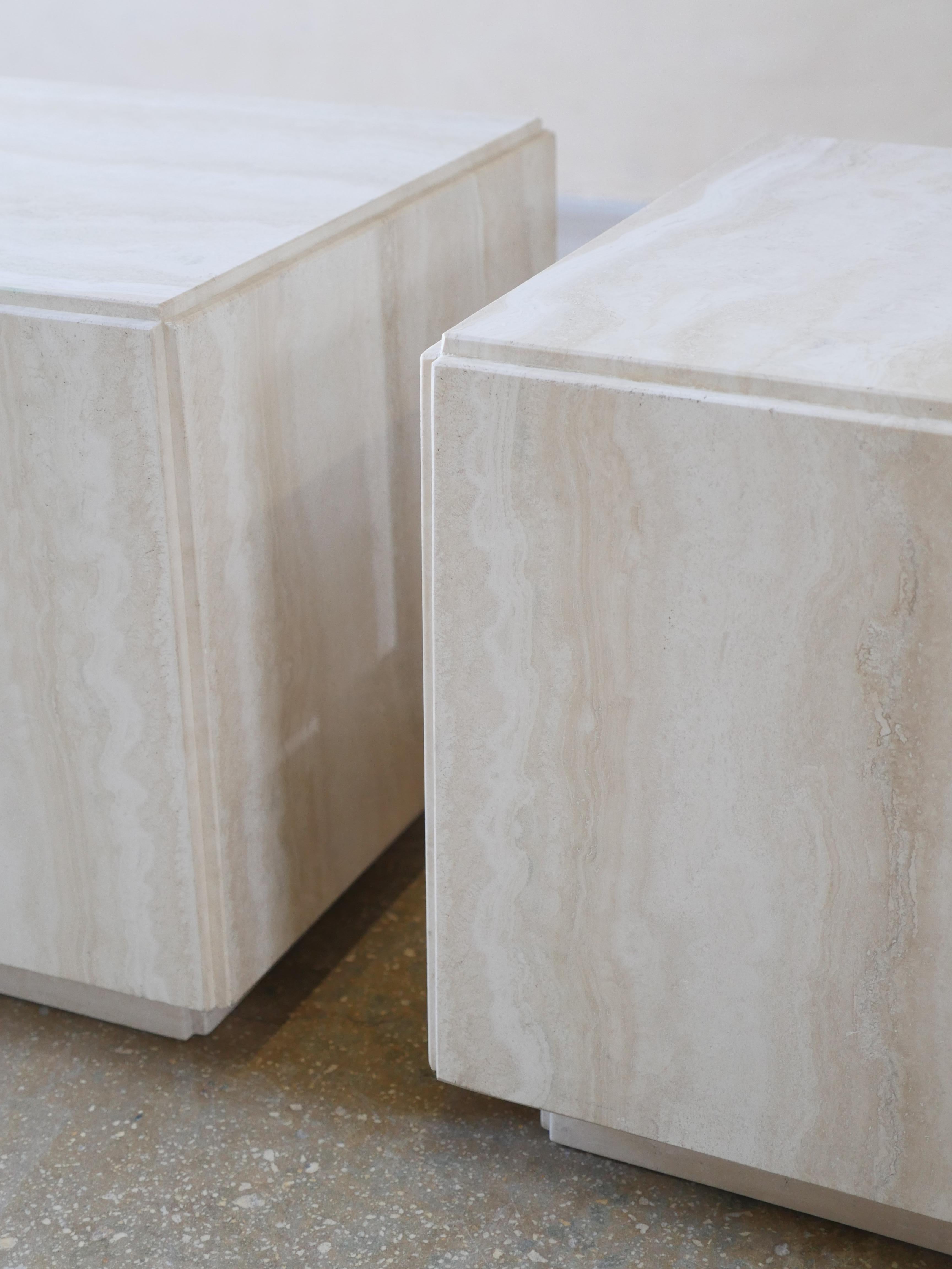 Vintage pair of polished, Italian Navona travertine cubes on plinths. These beautiful travertine, vein cut postmodern cubes have a nice off-white/light cream color to them, and can be used as side tables, or a coffee table.