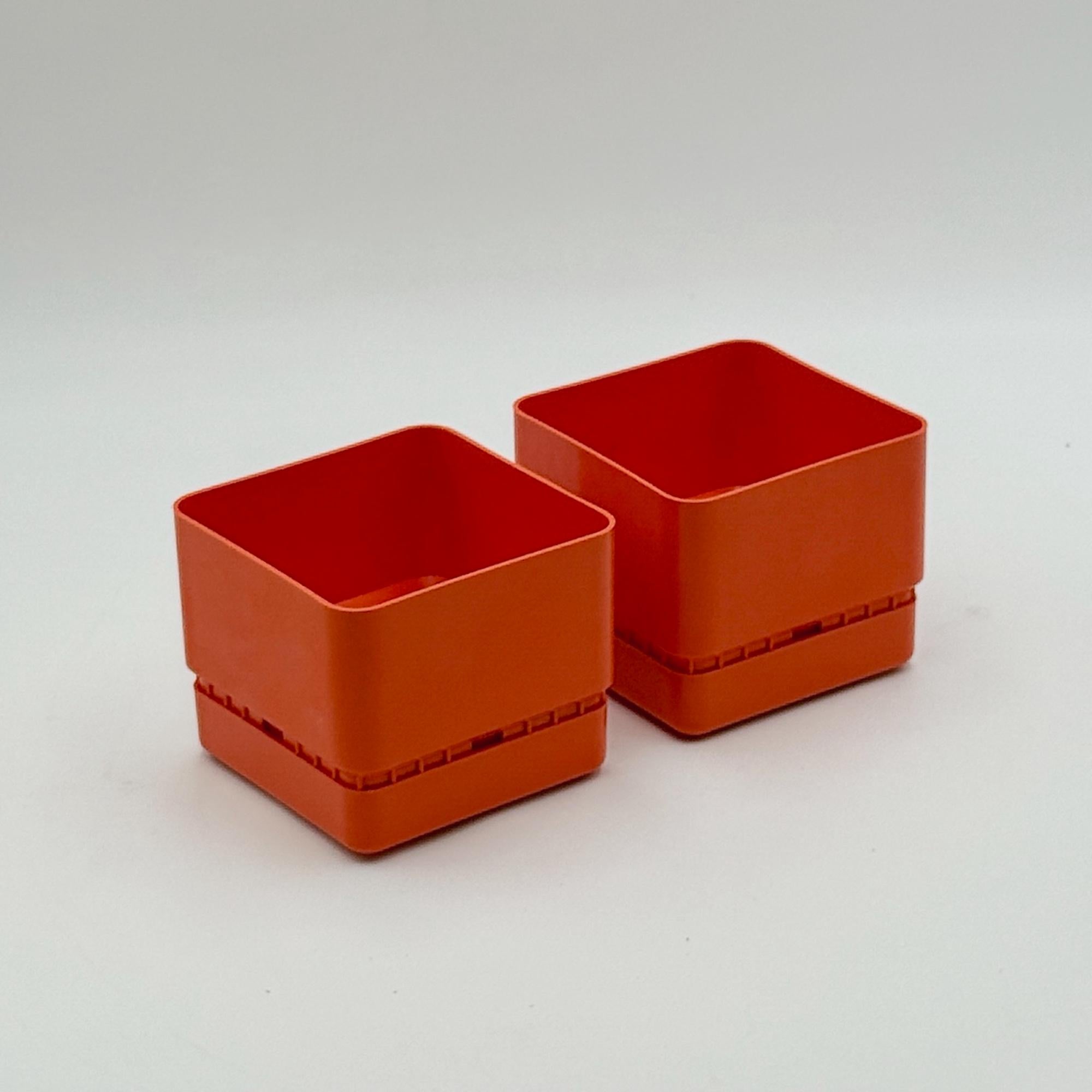 Questa coppia di fioriere in plastica arancione, modello Classic - Square F120, è stata disegnata da Nena Balsari per Vastill by Reflex e prodotta in Italia negli anni Settanta. Caratterizzate da un colore deciso, una forma quadrata e una