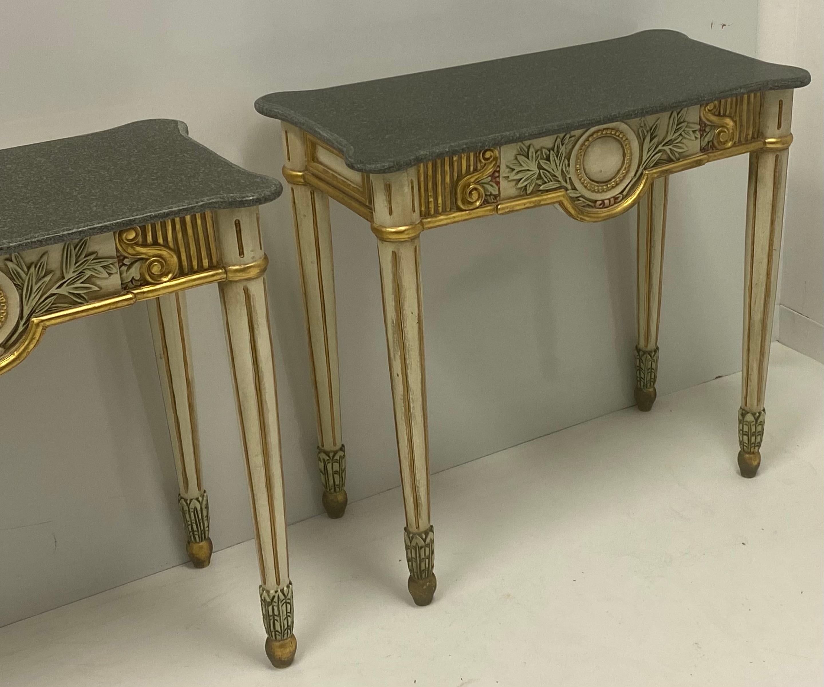 This is a pair of giltwood Italian console tables with granite tops. The tops are not attached, and both the bases and tops are in very good condition. The pieces are unmarked.
