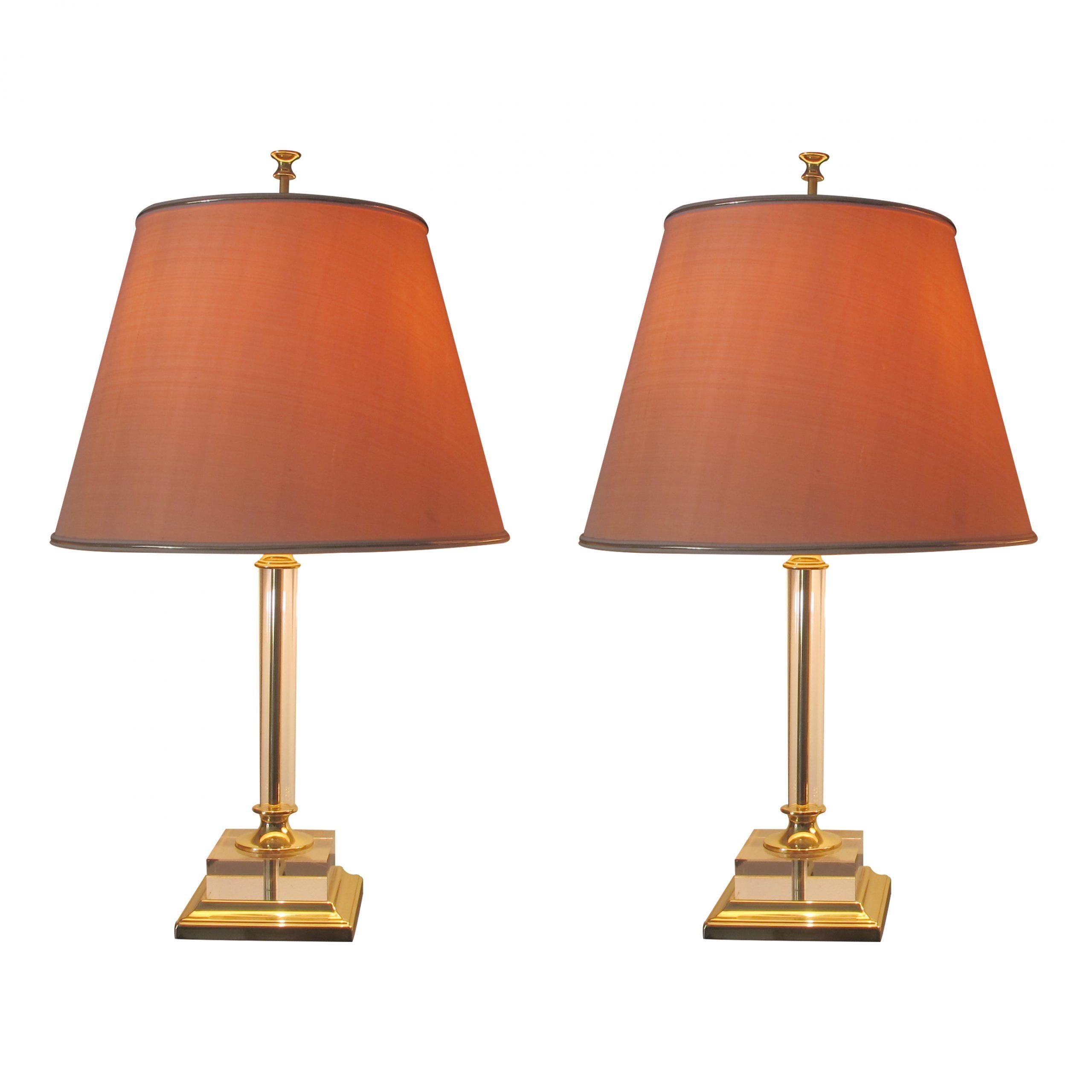 Italian large pair of lucite and brass table lamps with their original shades, in great condition. This is a timeless elegant design; the lamps are presented on a brass base with a thick acrylic square and a tubular stem. The cream shades change
