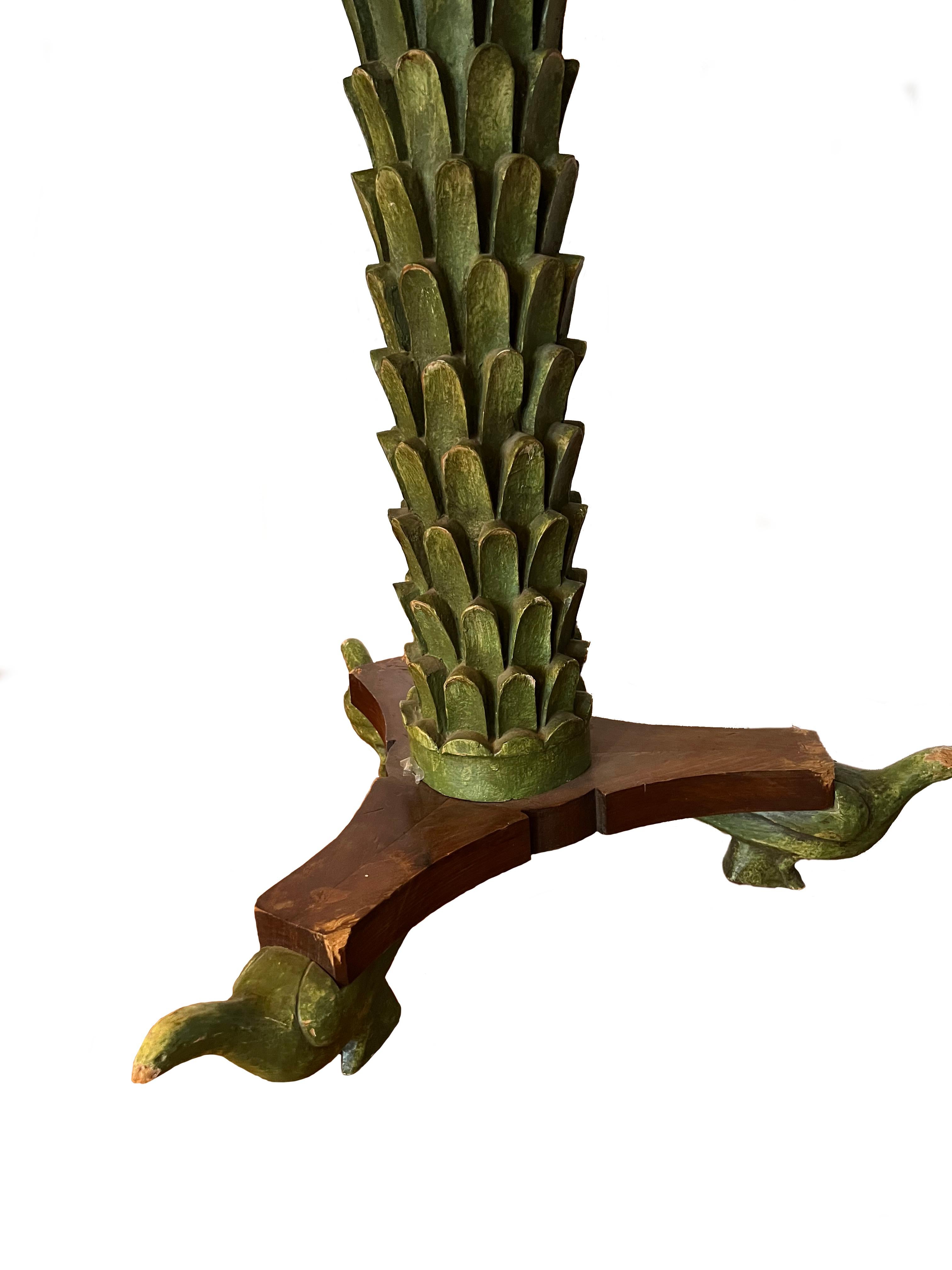 An Italian painted sidetable made of out carved sections and decorated in green accented pieces such as the marble top, the bird feet and palm stem. The hand carved palmette form pedestal supported three sprayed legs with stylized bird formed feet.