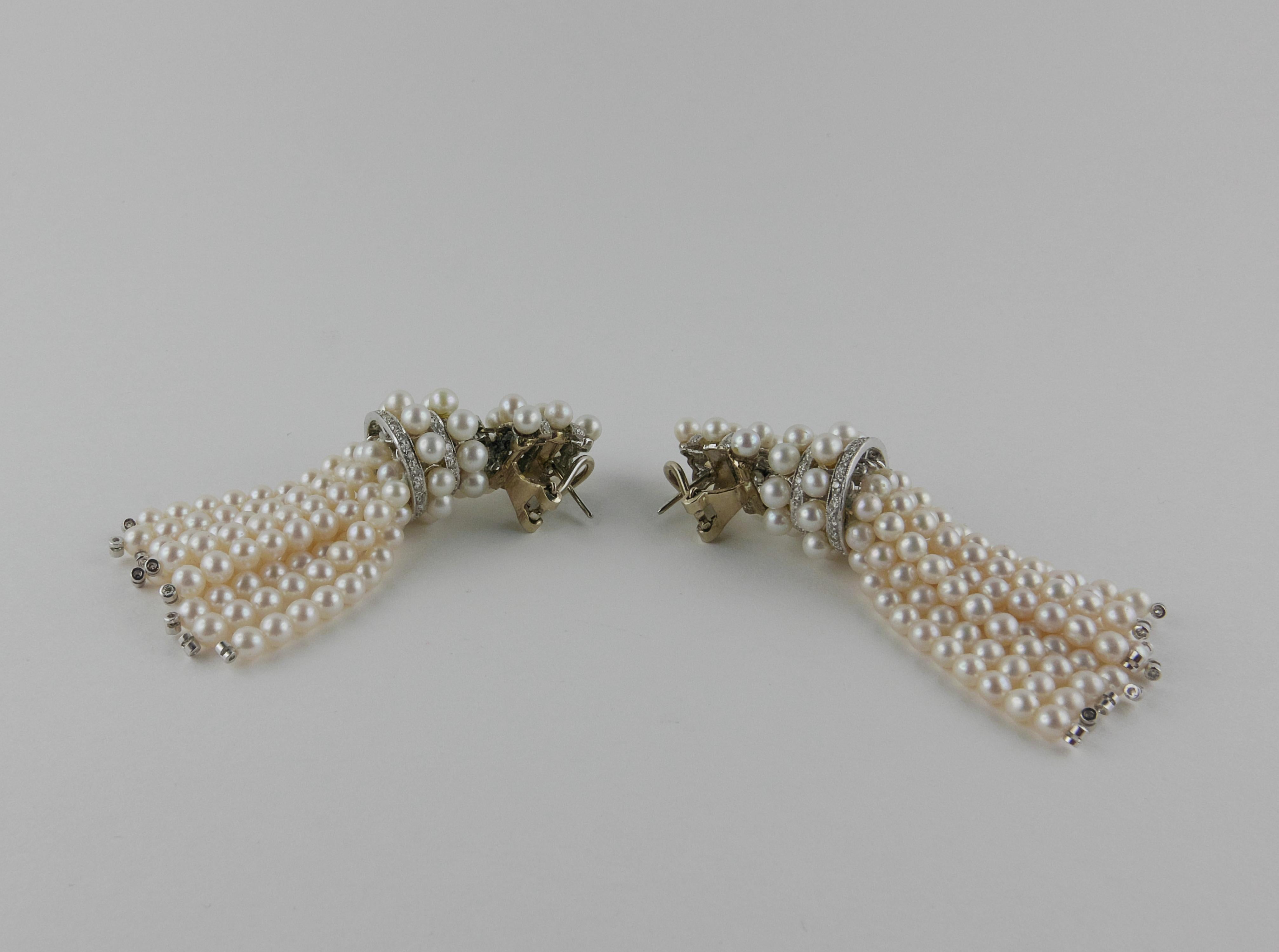 An extremely chic pair of long tassel drop Earrings, each featuring 10 strands of 10 round cultured white Pearls with small Diamond bead ends, suspended from pave` set Diamond rondells  alterned with Pearls rondells all set in white Gold and
