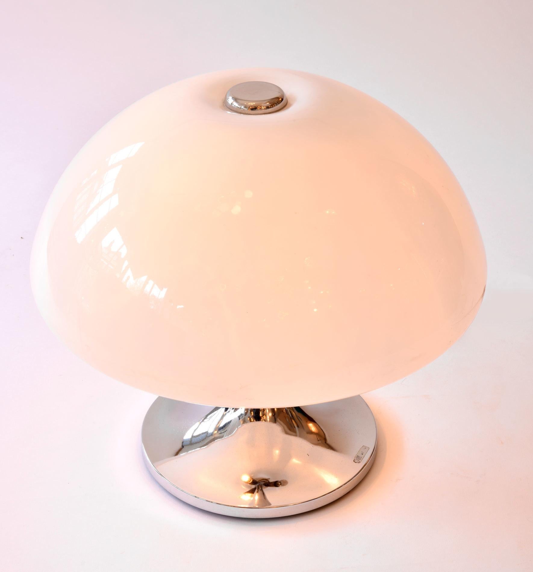 Curvaceous table lamp with domed acrylic shade topped with decorative chrome disk.
Sits on curved base.
