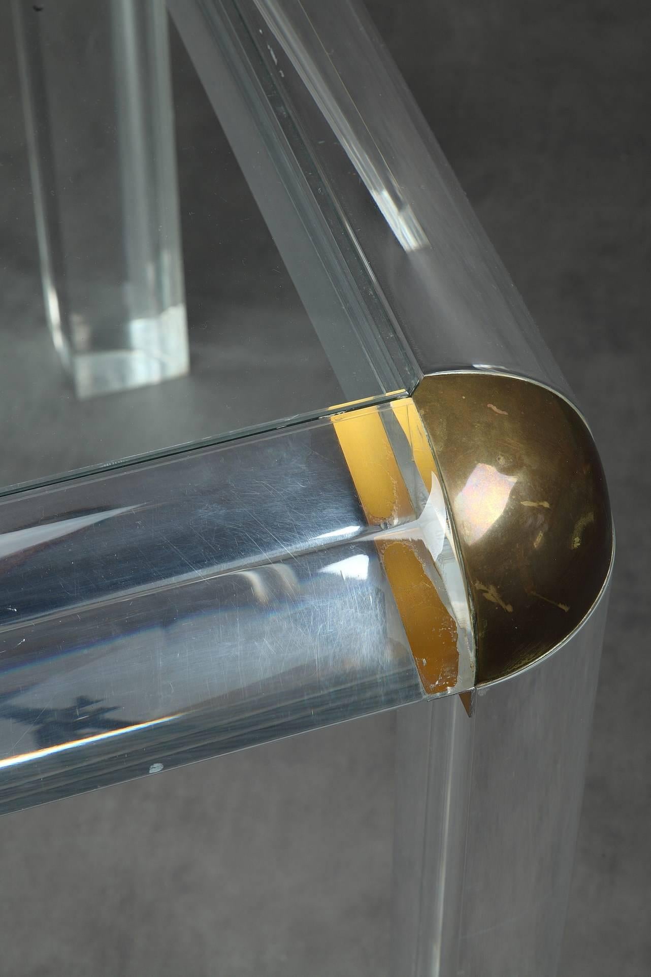 Important plexiglass (Lucite) table with round gilded brass corners and glass tray. It is set on four quarter cylinder feet. Beautiful Italian work of the 1970s.,

circa 1970
Dimension: W 62.2 in, D 34.6in, H 29.5in.
Dimension: L 158cm, P 88cm,