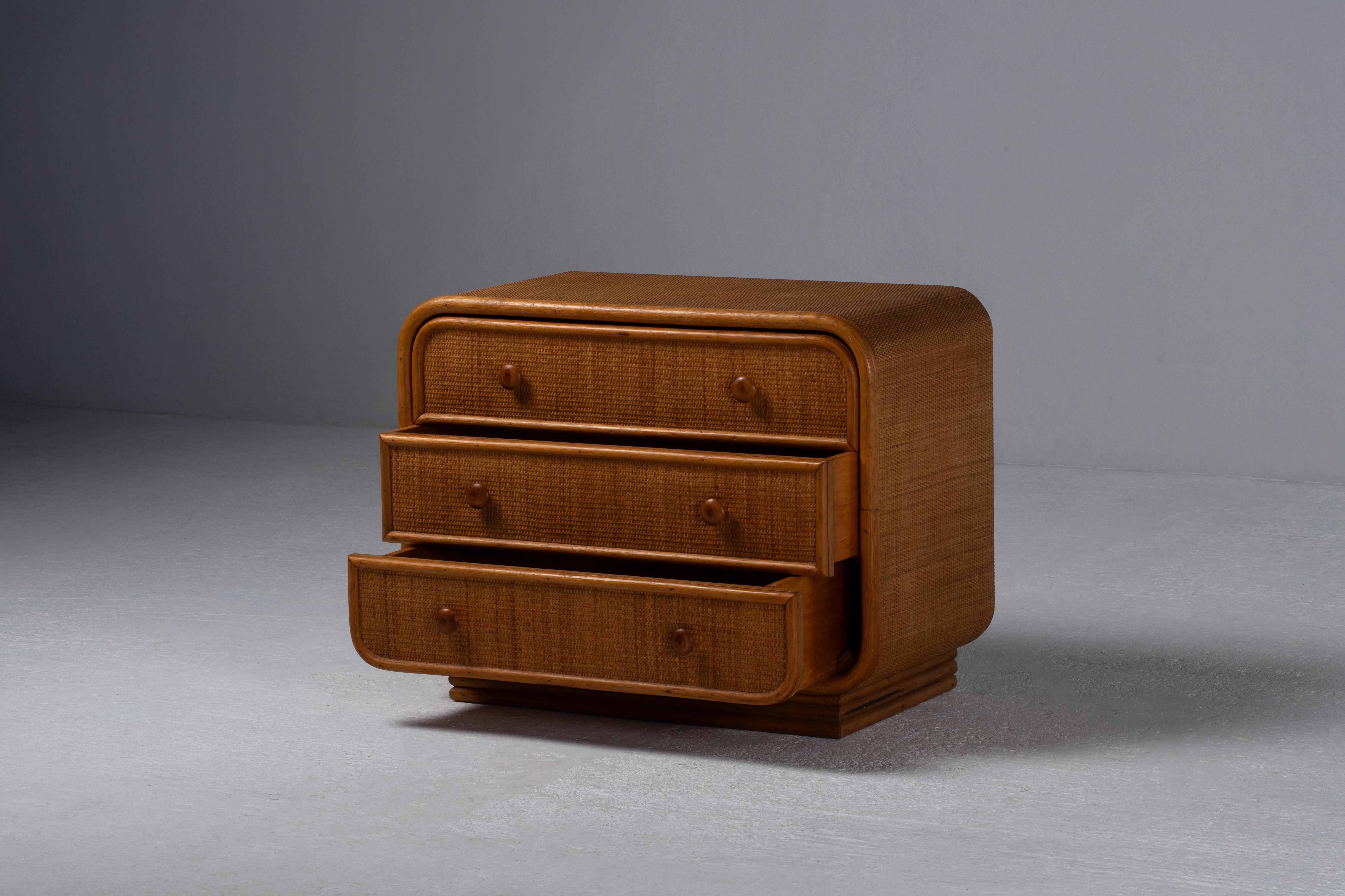 Diese Kommode aus Rattan und Bambus ist ein raffinierter Ausdruck italienischer Handwerkskunst der 1970er Jahre und verkörpert die mühelose Eleganz des organischen, modernistischen Designs. Seine sanft geschwungene Silhouette wird durch geflochtene