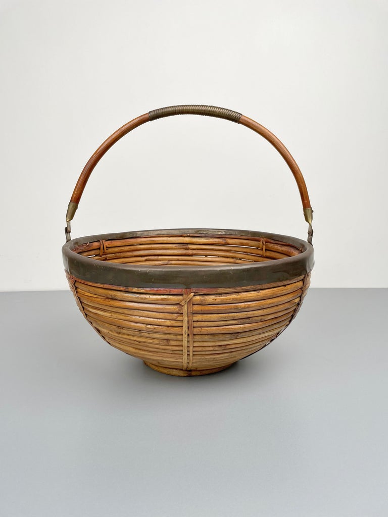 Large basket with handler in rattan and brass details made in Italy in the 1970s.