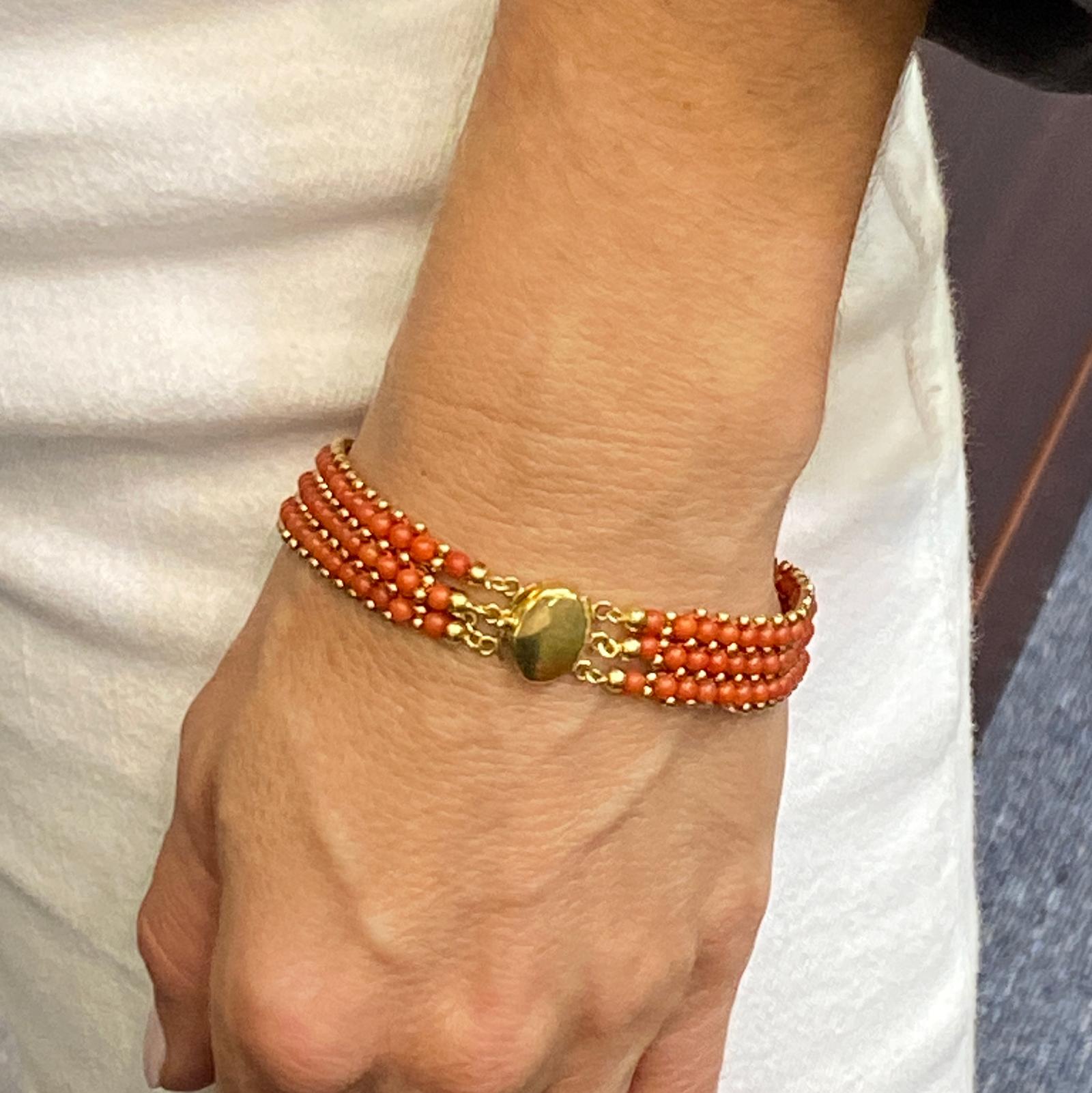 Italian red coral bracelet fashioned in 18 karat yellow gold. The bracelet features three rows of beautifully matched red coral beads, and measures 7.5 inches in length, .50 inches in width. Stamped 750 with Italian hallmarks . 