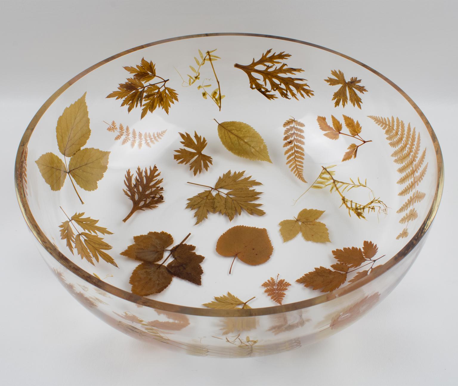 Very elegant 1970s resin decorative bowl, centerpiece, or serving dish by Resinplast, Italy. Extra thick clear resin or acrylic deep rounded oversized bowl shape with assorted real autumn leaves and dried flowers embedded in the material. The