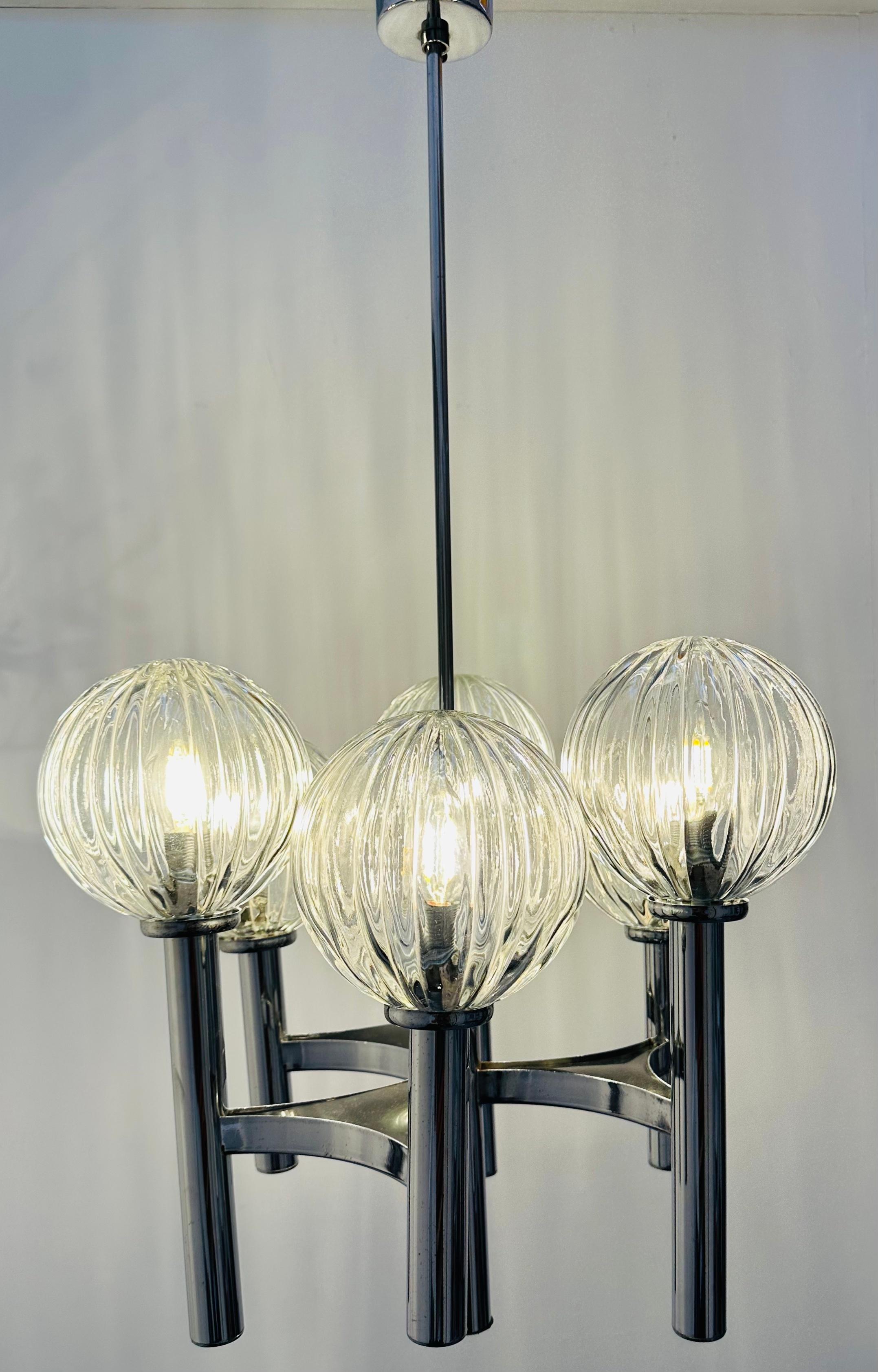 1970s Italian glass globe and polished chrome chandelier. Attributed to Gaetano Sciolari for Sciolari Lighting.   The six thick and heavy vertically-ribbed clear-glass globes securely clip onto the vertical chrome tubular columns which are connected