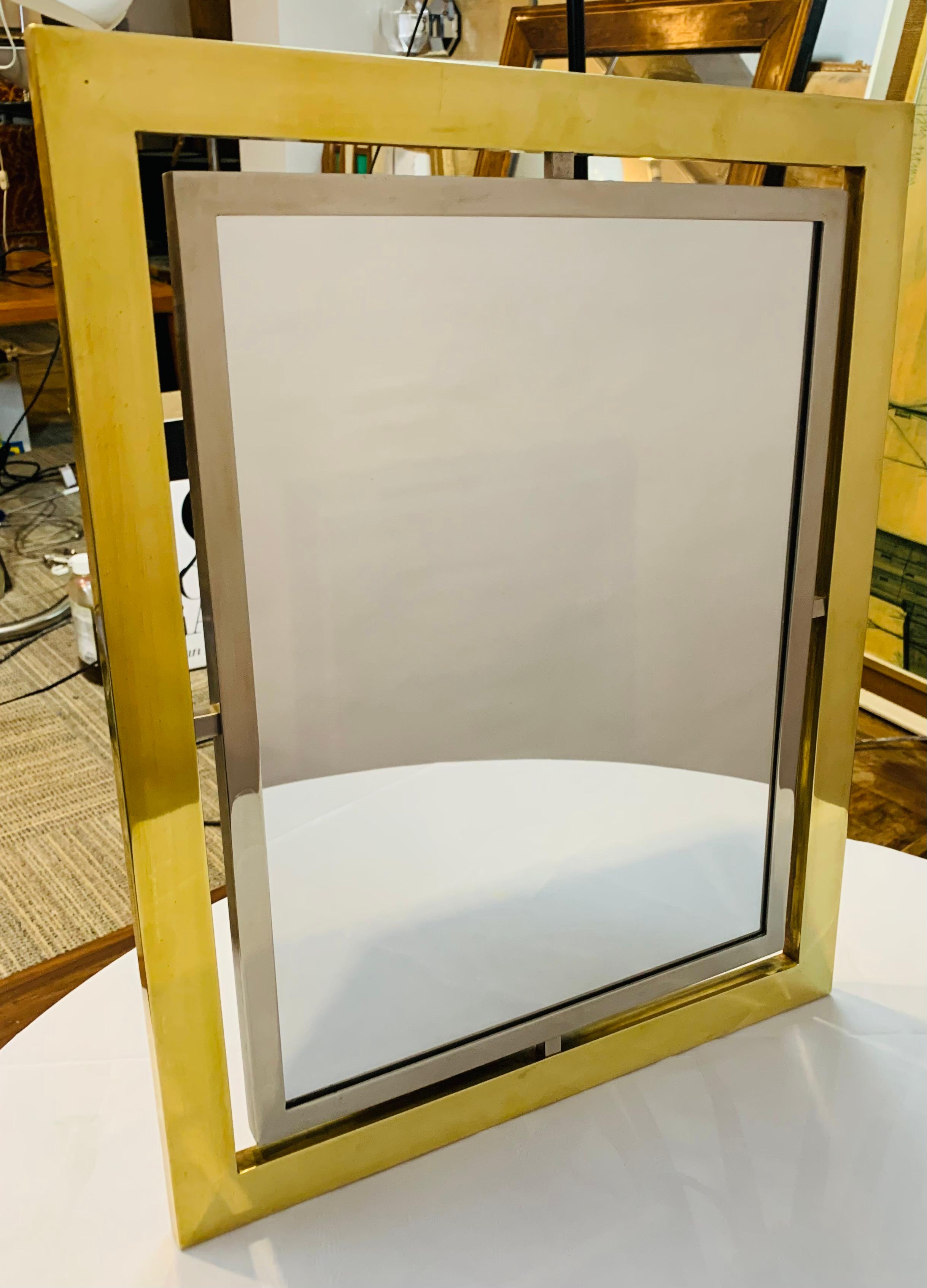 1970s Italian Romeo Rega rectangular free-standing dressing table mirror in polished brass and brushed steel. The mirror could easily be converted to a wall mirror if required. The mirror sits within a brushed steel frame which is suspended inside