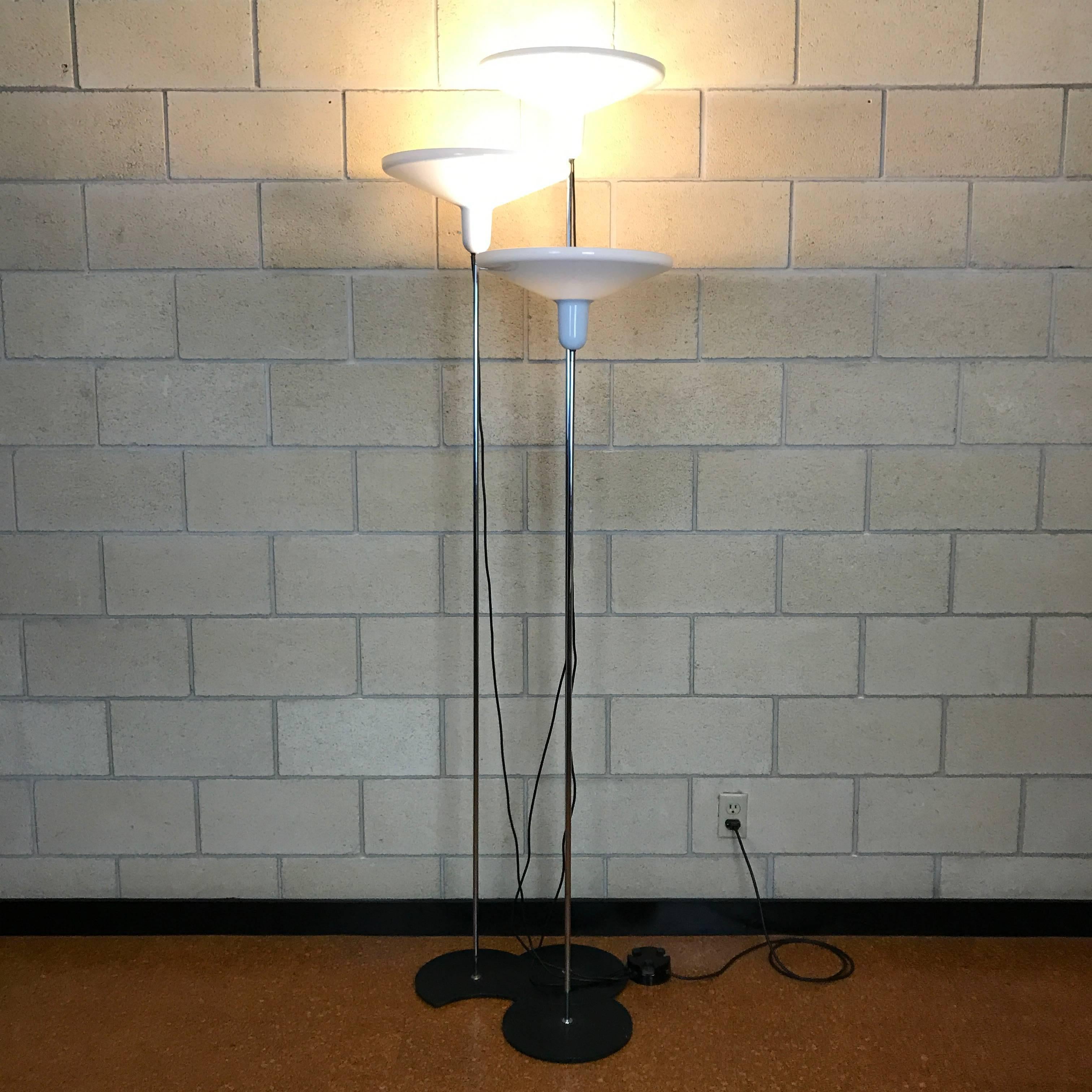 Beautiful set of three Italian Modern floor lamps made of metal and acrylic by Harvey Guzzini for Harveiluce; Made in Italy. Each lamp is on a half-moon style base that allows it to nest with the other two lamps to create the design you desire.