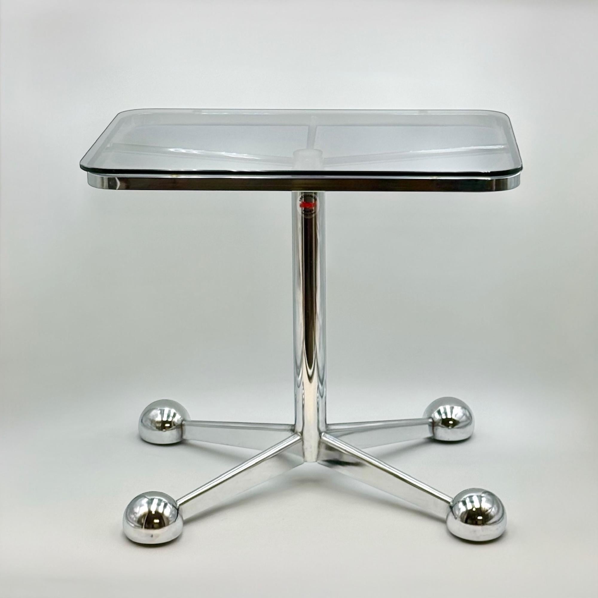 Cette table sculpturale des années 1970, créée par Allegri Parma, est une pièce remarquable du design italien de l'ère spatiale. Fabriqué en Italie, il comporte un axe central télescopique en métal chromé, soutenu par quatre pieds angulaires à