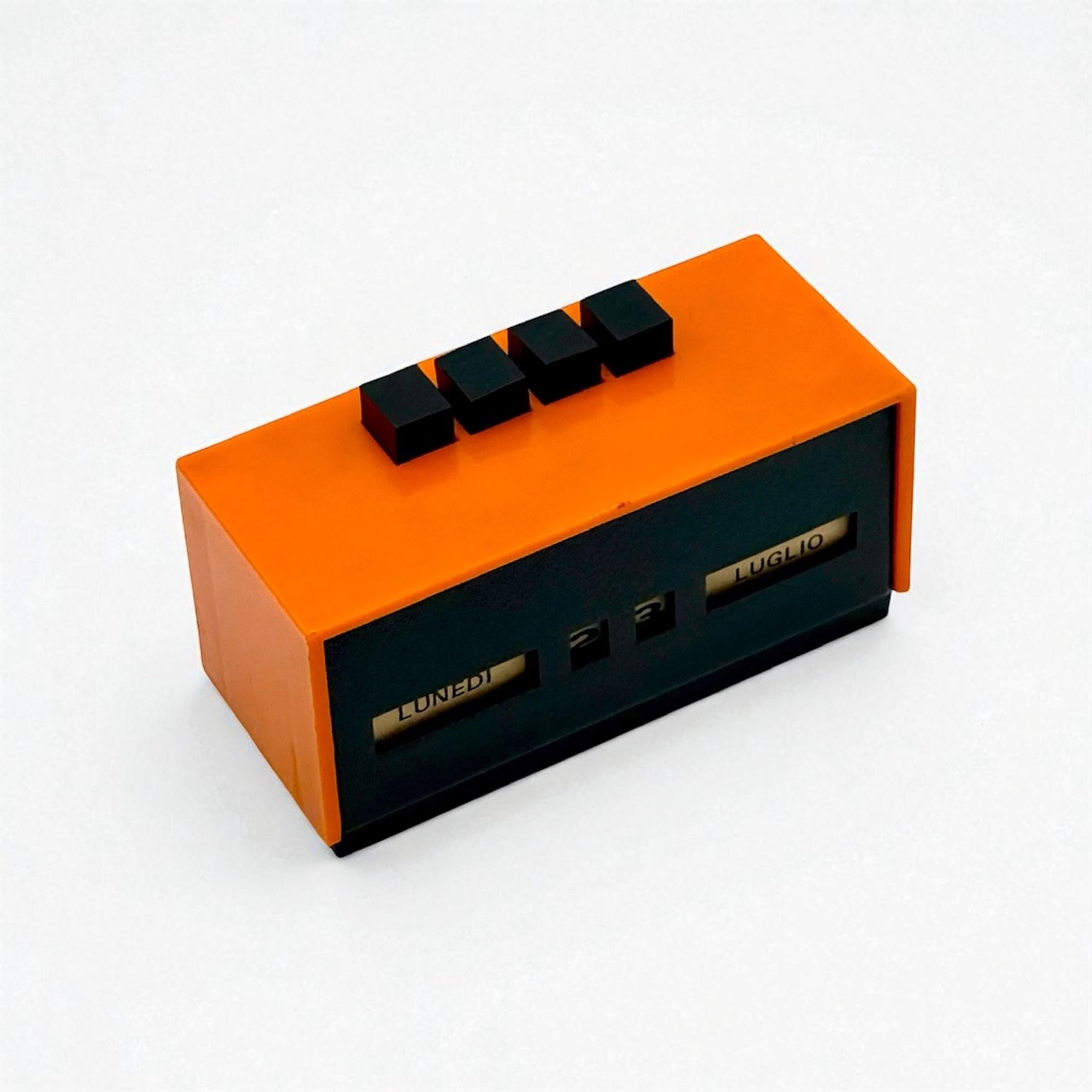A rare and characterful Italian space age perpetual calendar dating from the 1970s, designed during the golden era of futuristic home accessories. This model is crafted in bright orange plastic with a black front panel and features a manual scroll
