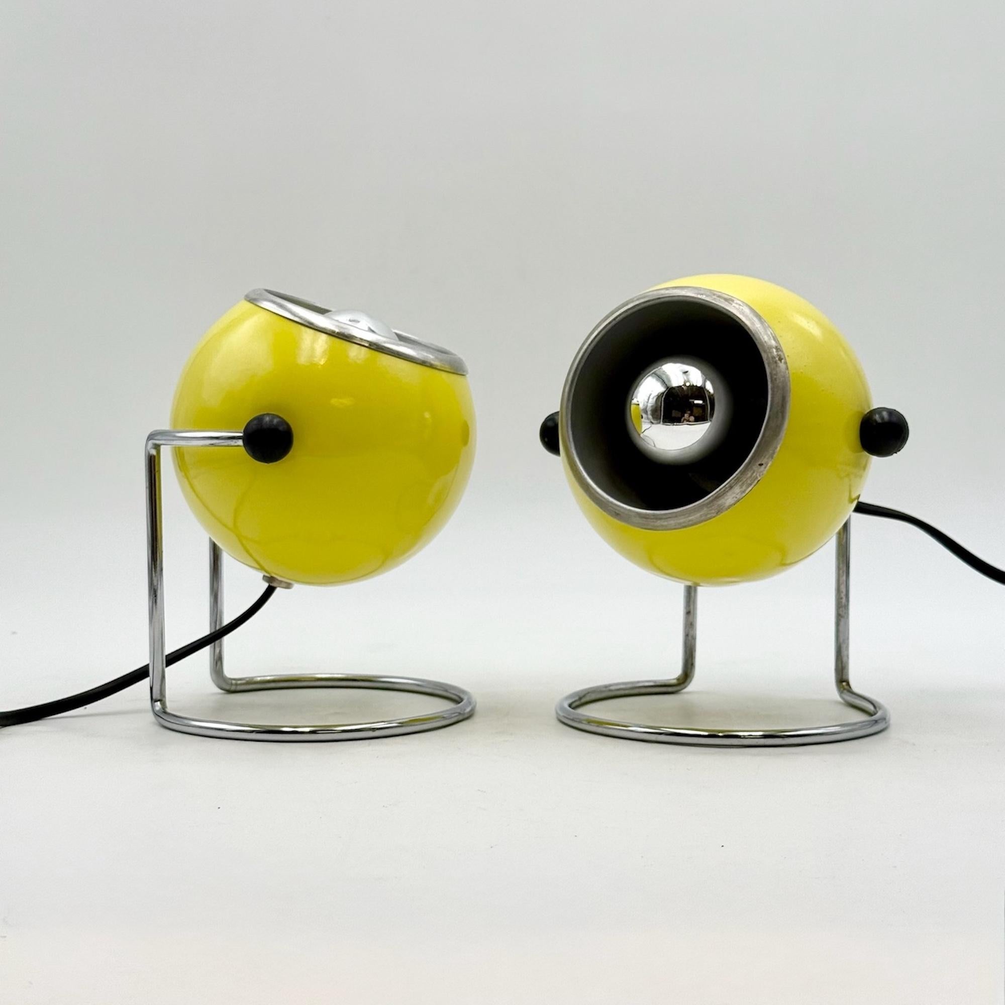 Une paire frappante de lampes de table à globe oculaire conçues par Design/One, fabriquées en Italie dans les années 1970. Ces lampes de collection incarnent le meilleur du design de l'âge de l'espace avec leurs abat-jours hémisphériques jaune