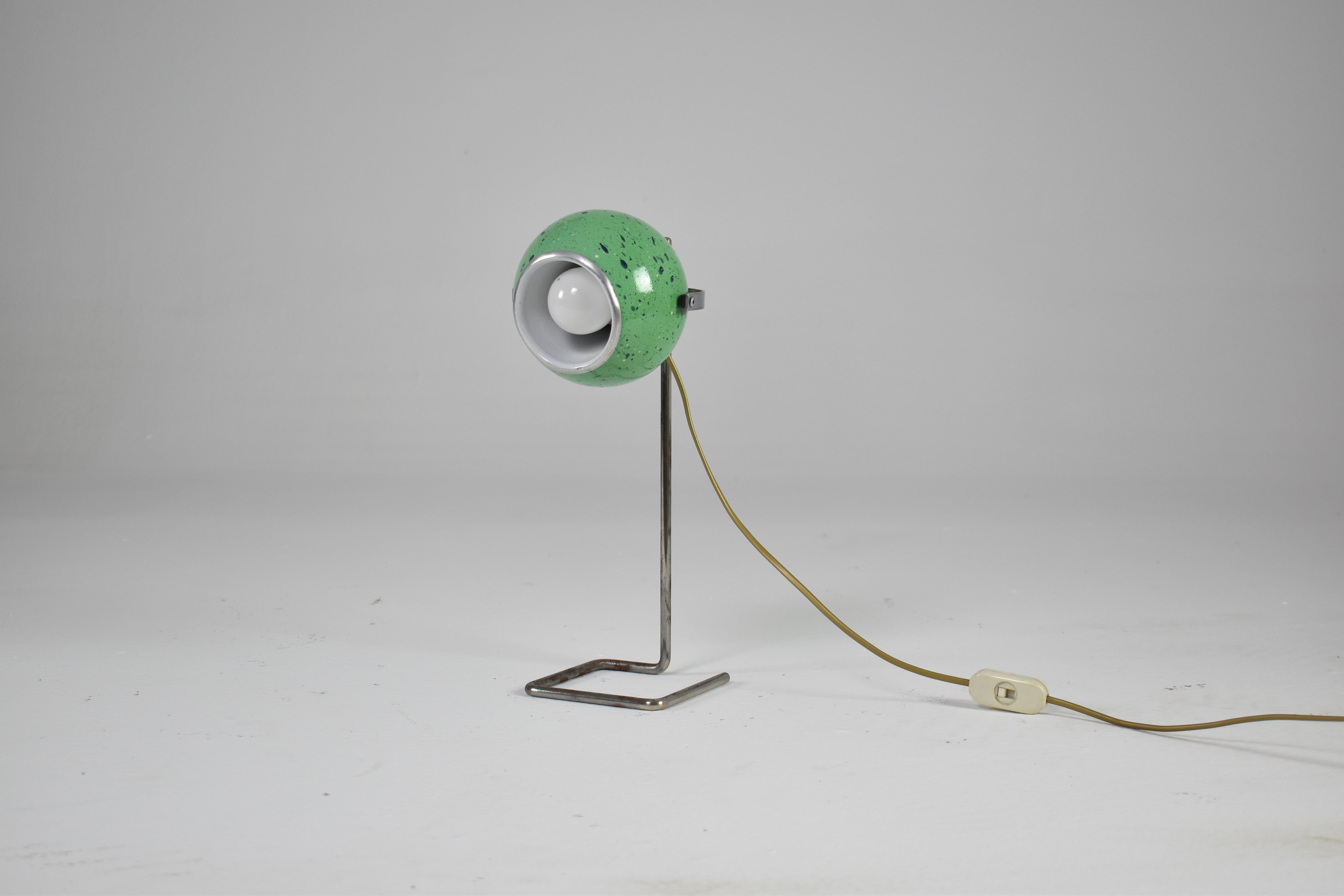 
Playful Italian vintage Space Age desk lamp with an adjustable ball shade in apple-green speckled enamel and a satin-white internal reflector. The shade sits on a chromed steel rod base with inline switch. Perfect scale for a desk, bookshelf, or