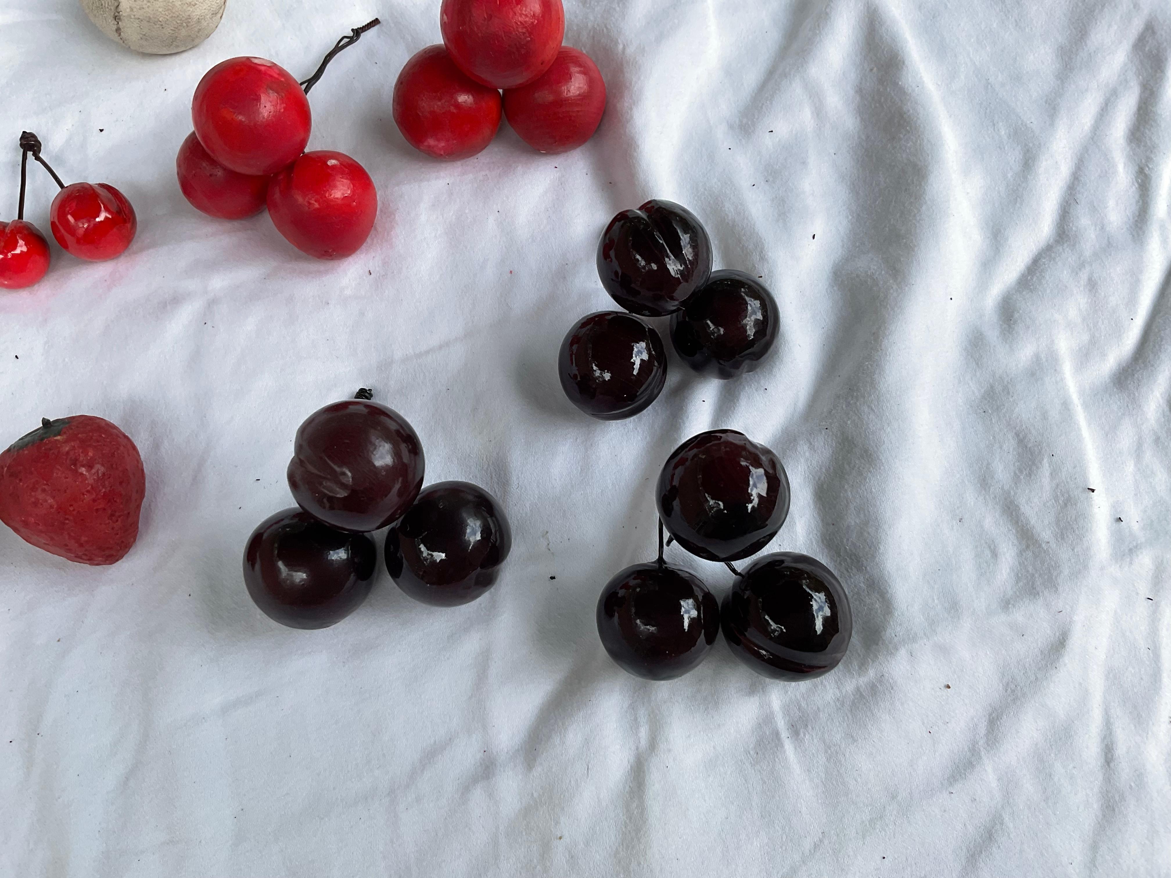 This bunch of mainly cherries, has been purchased at different times, in different places. There are 2 bunches of 3 cherries each, in a pinkish red color. There are 3 bunches of dark red cherries. There are 2 stems, with 2 small cherries each. Also,