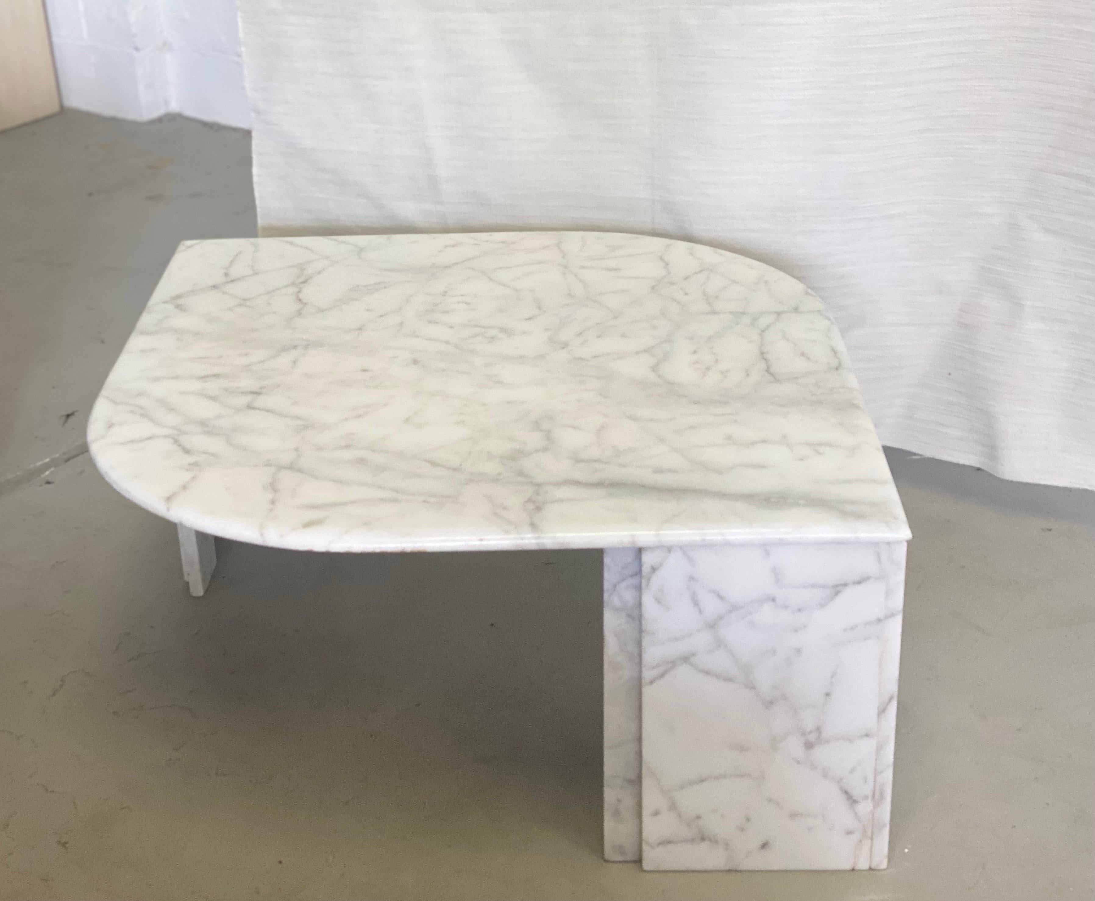 We are very pleased to offer a minimal, white marble coffee table, circa the 1970s. A polished marble teardrop tabletop rests on two faceted pedestals; in addition, a refined bullnose edge gives the coffee table a sophisticated finish. With its