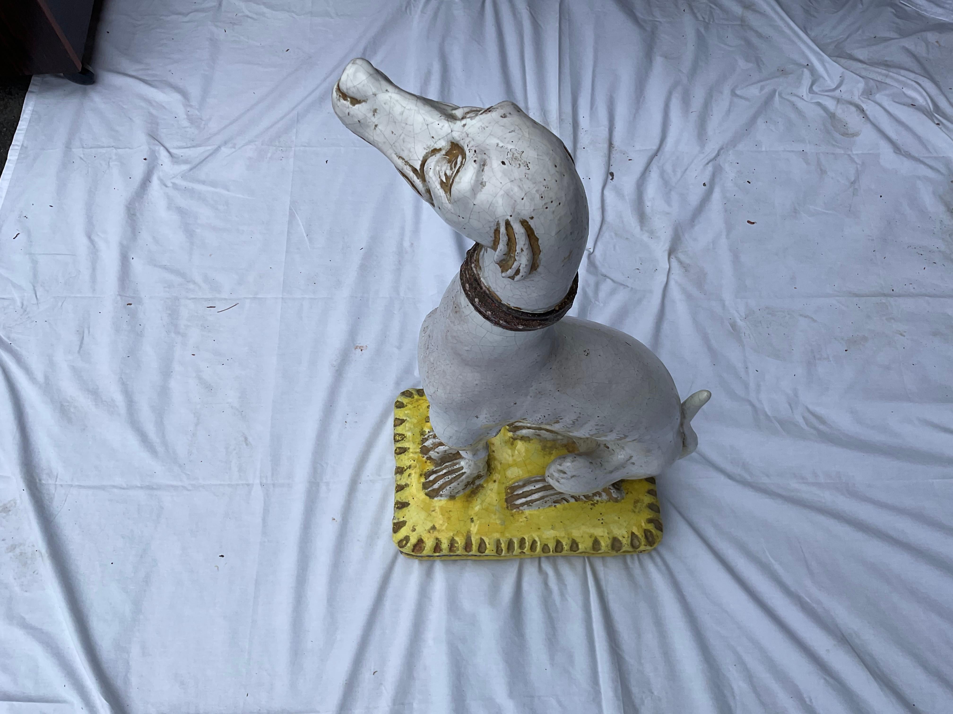 Unusual, and charming, seated Italian whippet. Hand painted, and sitting on a yellow pillow w/ rope design. This design of a whippet, is a little harder to find, than some others. Very obedient, waiting for its owner to claim it!