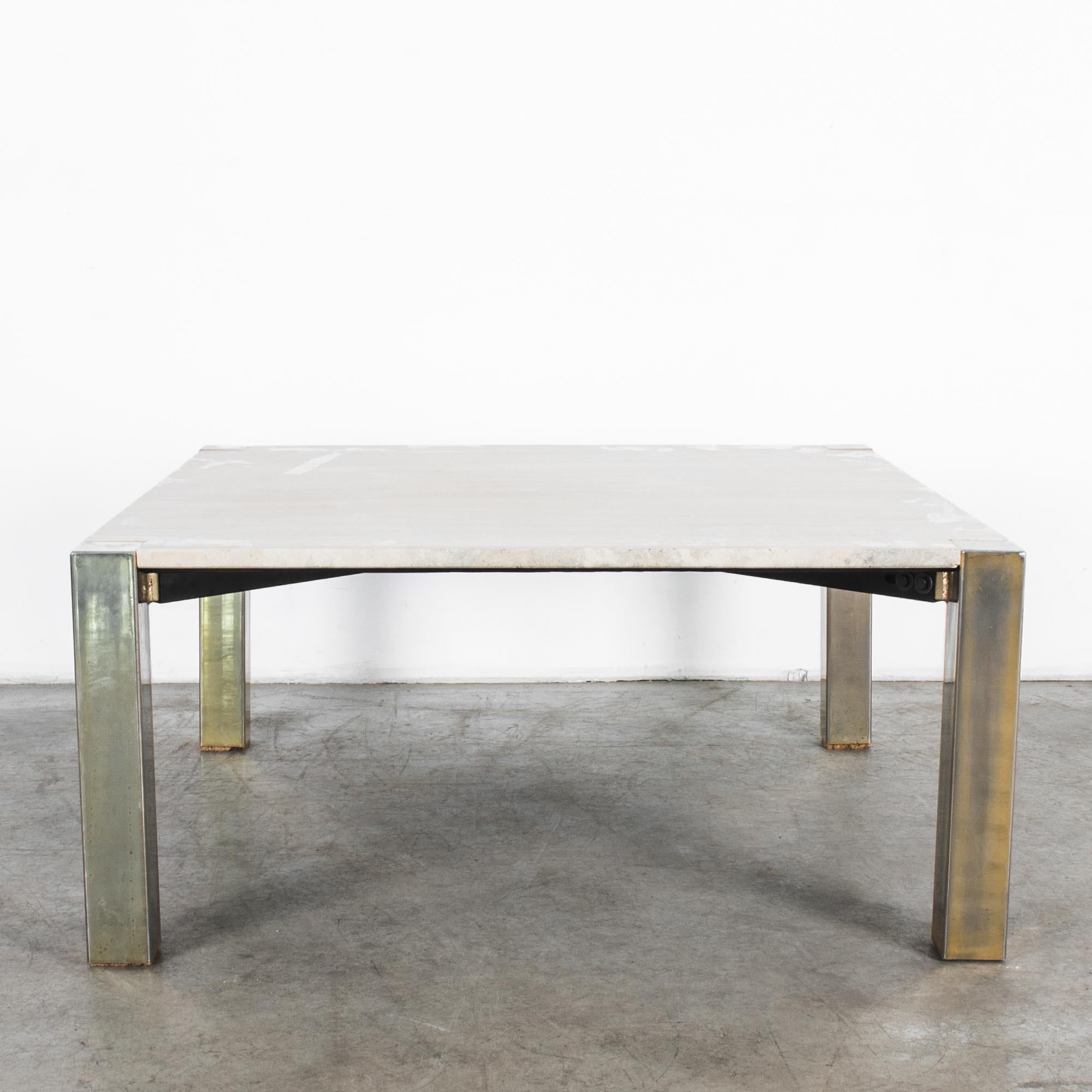 A sleek design from Italy, minimal metal legs, plated in brass, hold a square travertine top in this 1970s coffee table. One meter by one meter, carefully polished and cut, the brass legs interlock with stone to complete the Stark geometric form.