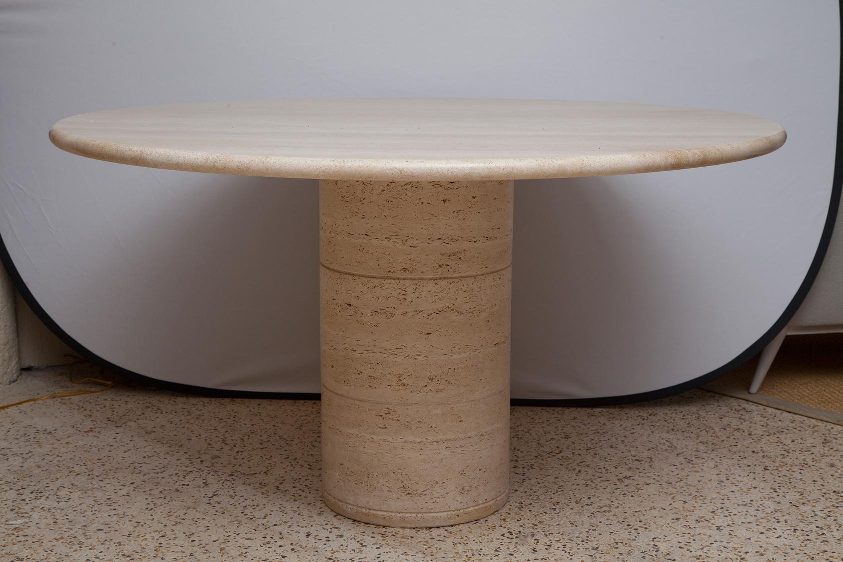 A hollow center column of honed travertine supports a round polished travertine top in this 1970s Italian marble table, designed in the style of Mario Bellini.