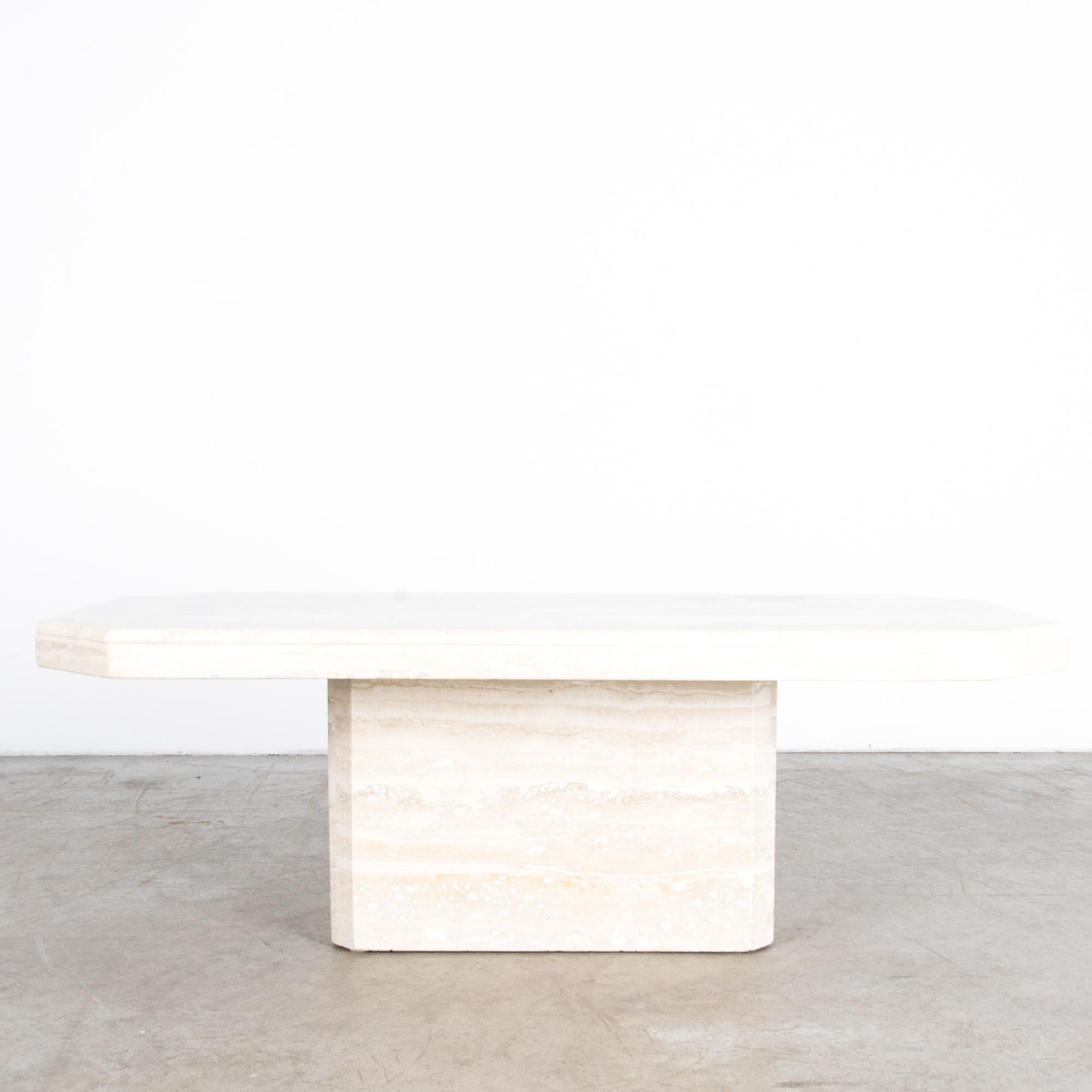 A travertine coffee table from Italy, circa 1970, the height of Italian ‘Bel design’. Modernist luxury meets perfect simplicity in this piece, made from a simple arrangement of Italian travertine: a hexagonal tabletop sitting atop a beveled block of