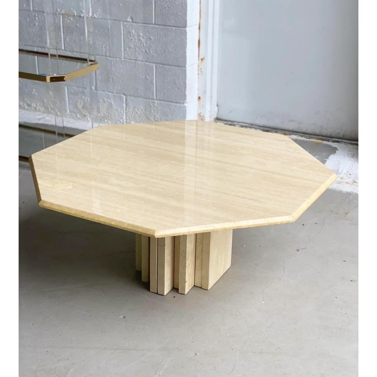 We are very pleased to offer a sculptural, travertine coffee table, made in Italy, circa the 1970s. This beautiful, architectural piece showcases a honed stacked pedestal base and a large lacquered octagonal tabletop, this juxtaposition of form and