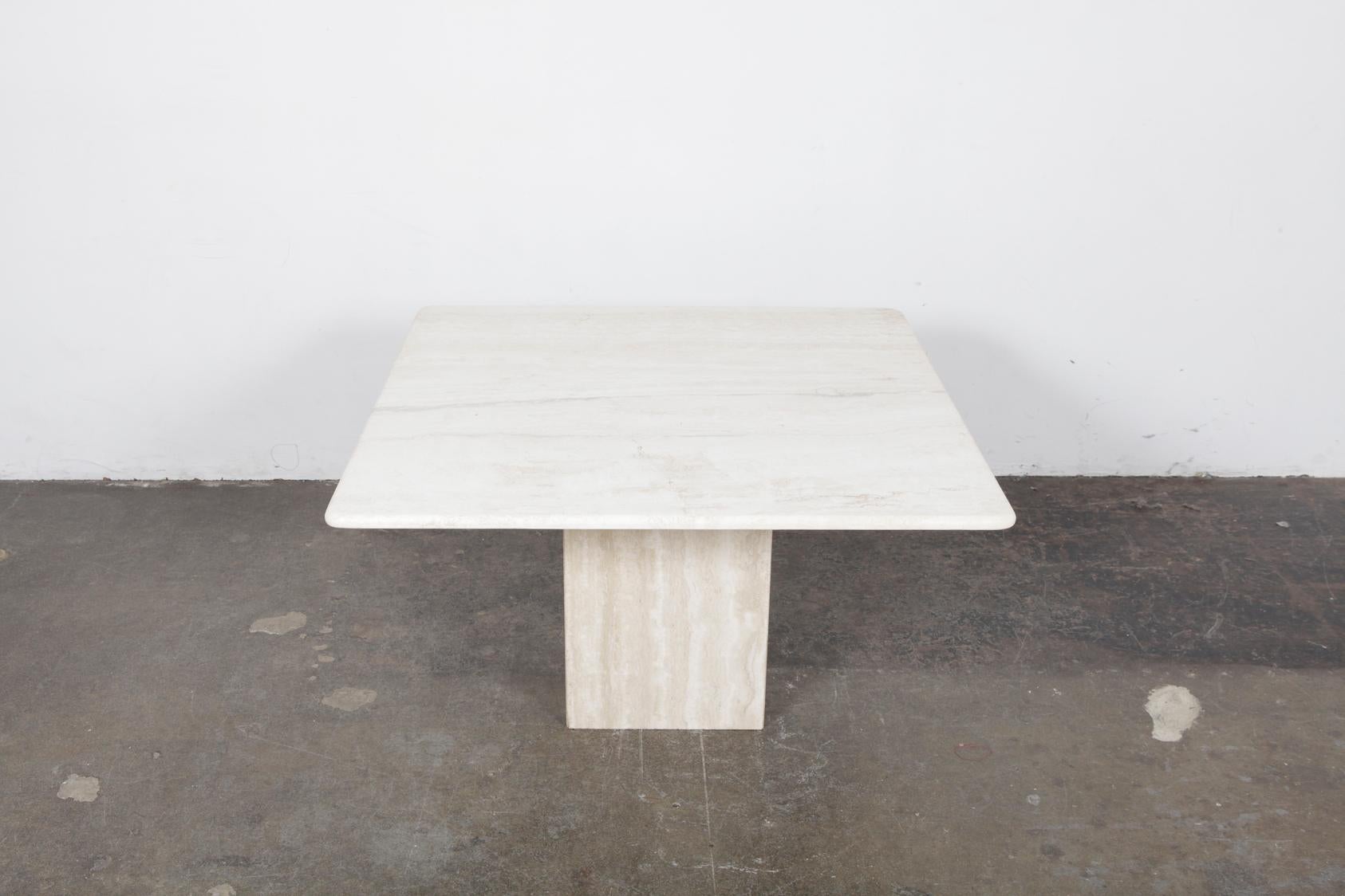 Beautiful Italian travertine coffee table, 1970s, with a square pedestal base and a slight beveled edge to the tabletop. In very nice vintage condition.
